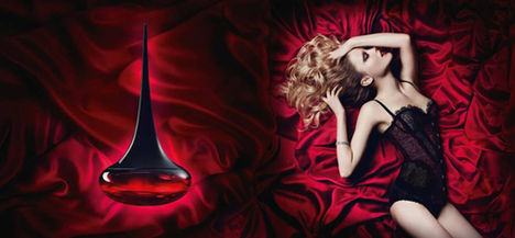Love Potion spread by Oriflame featuring model in black lingerie on red sheets and bottle of perfume