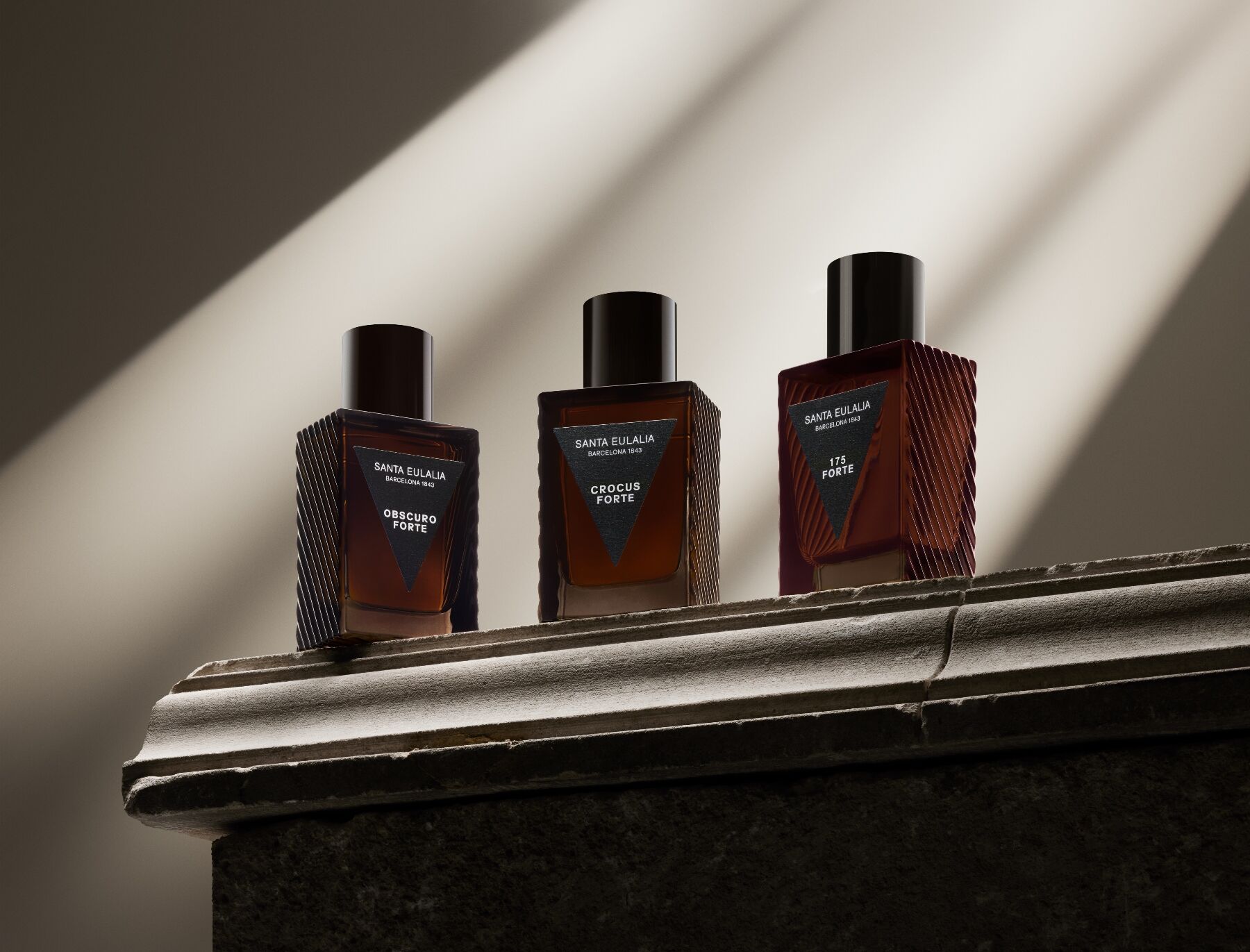Tři vůně z kolekce Forte na krbové římse