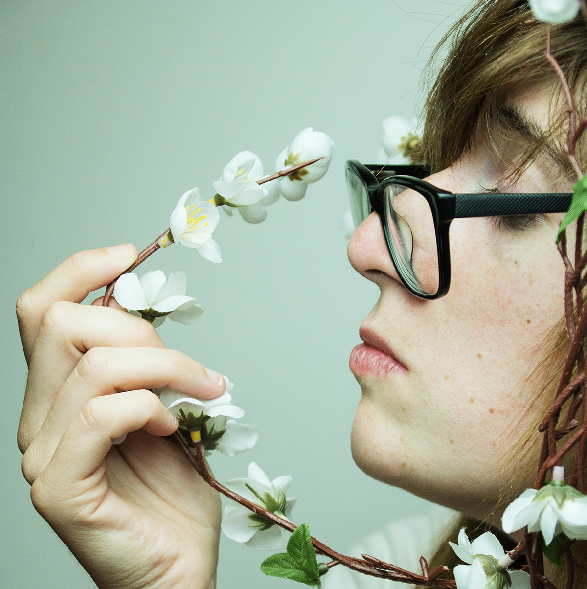 smelling a twig with flowers
