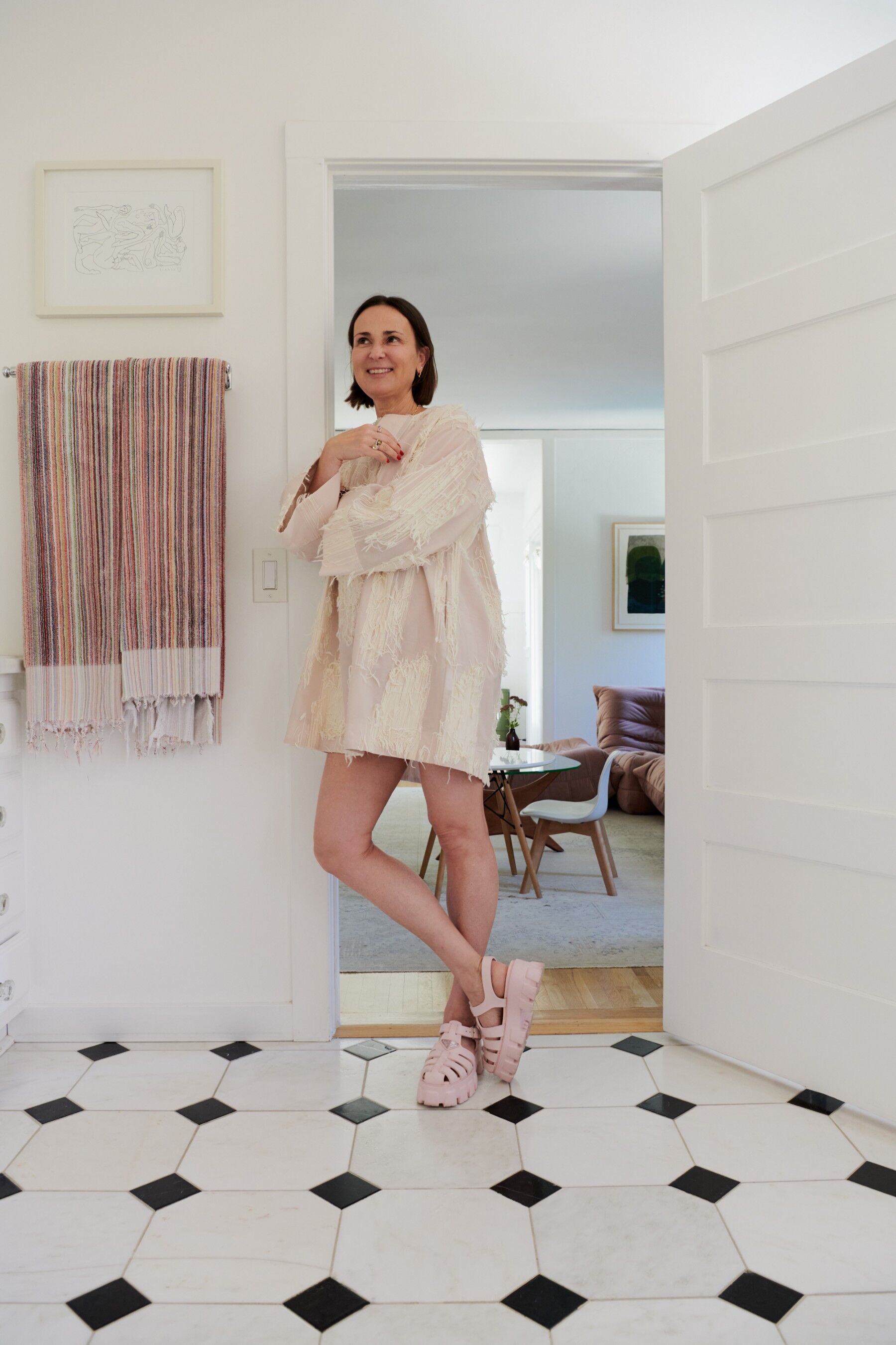Marie Petit du Thouars stands in a tiled room wearing a light pink sundress