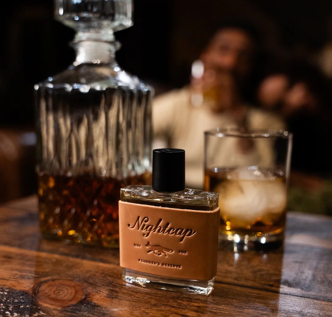 Nightcap Fragrance in front of a whiskey bottle.