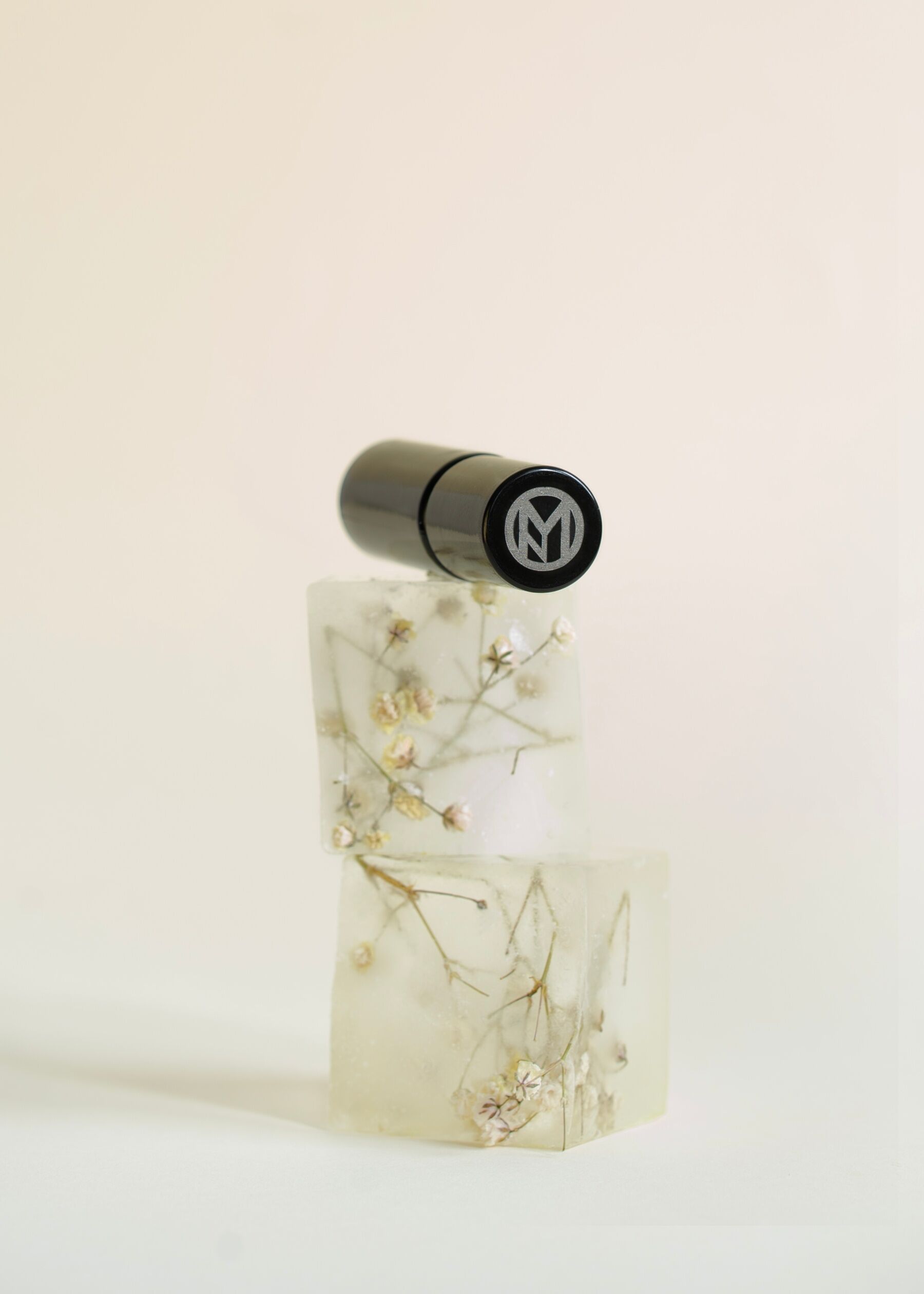 A bottle of Chloride set next to cubes which look like ice with flowers frozen into them