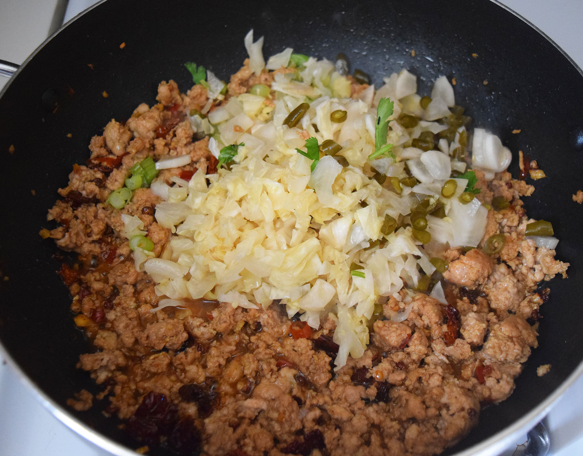 Adding the cabbage to the dish.