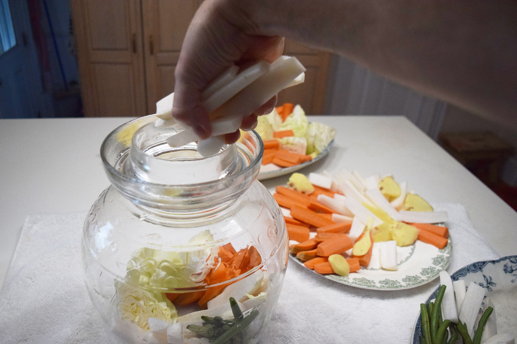 Adding daikon radish to the jar.