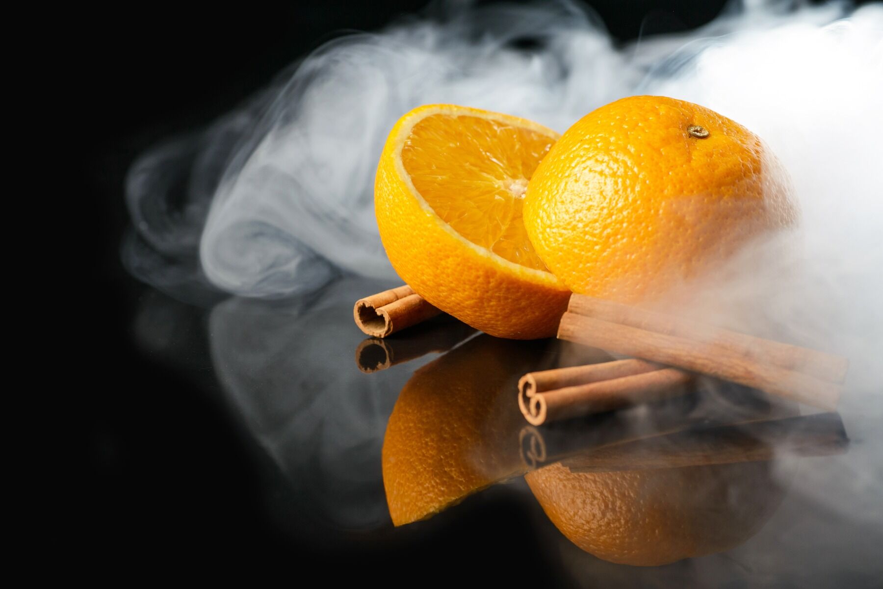 An orange pictured with smoke and some spices