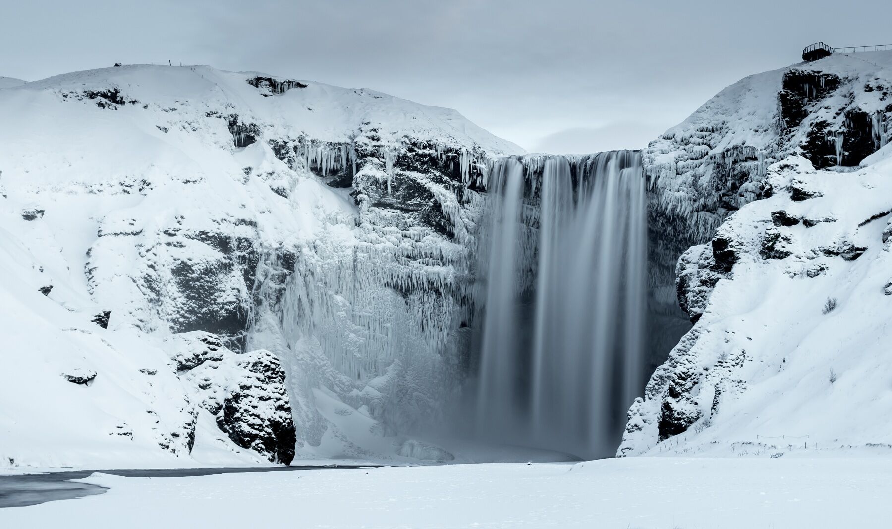 An icelandic waterfall in winter, covered in snow and frost