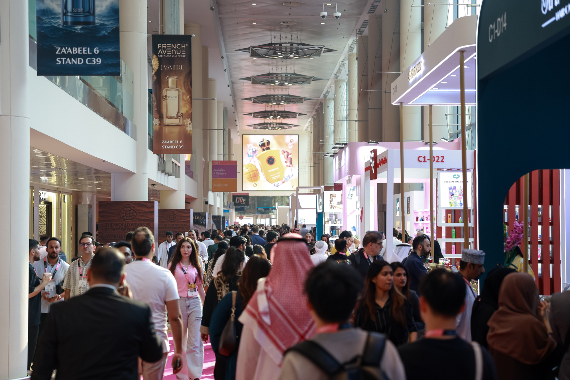 Interiér veletrhu, lidé kráčejí po růžovém koberci