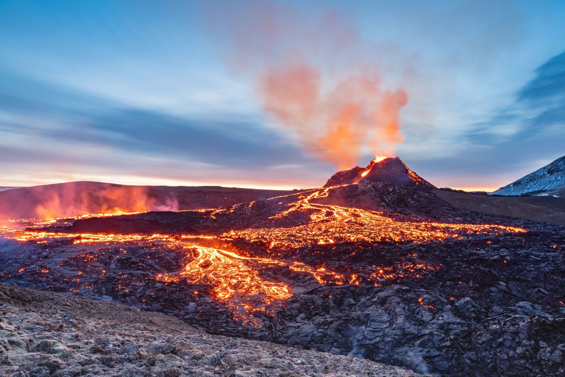 A volcano in Iceland erupting and showing flows of lava