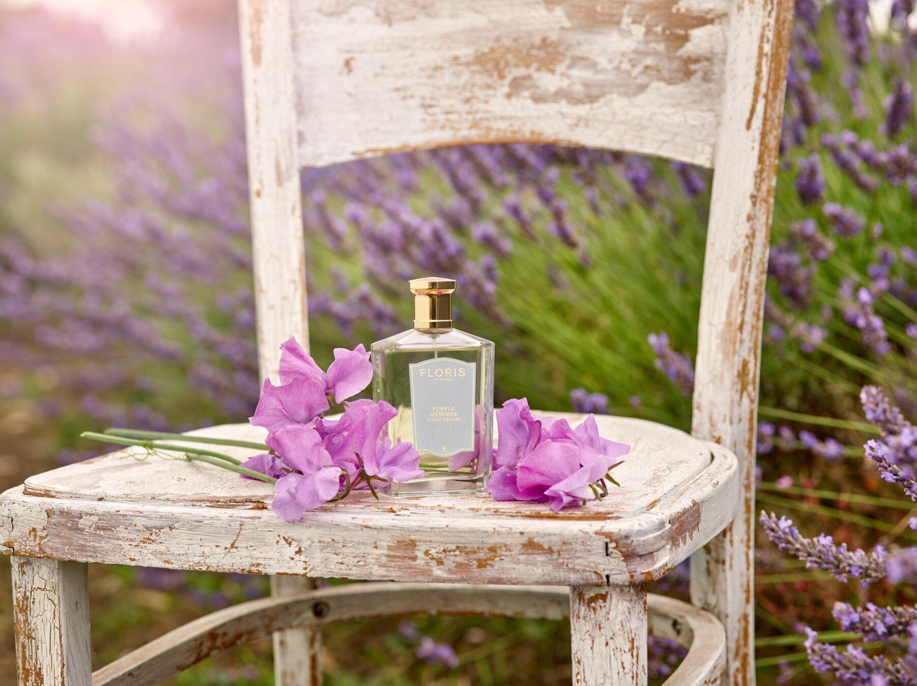 A bottle of Floris perfume on a chair in a field of lavender