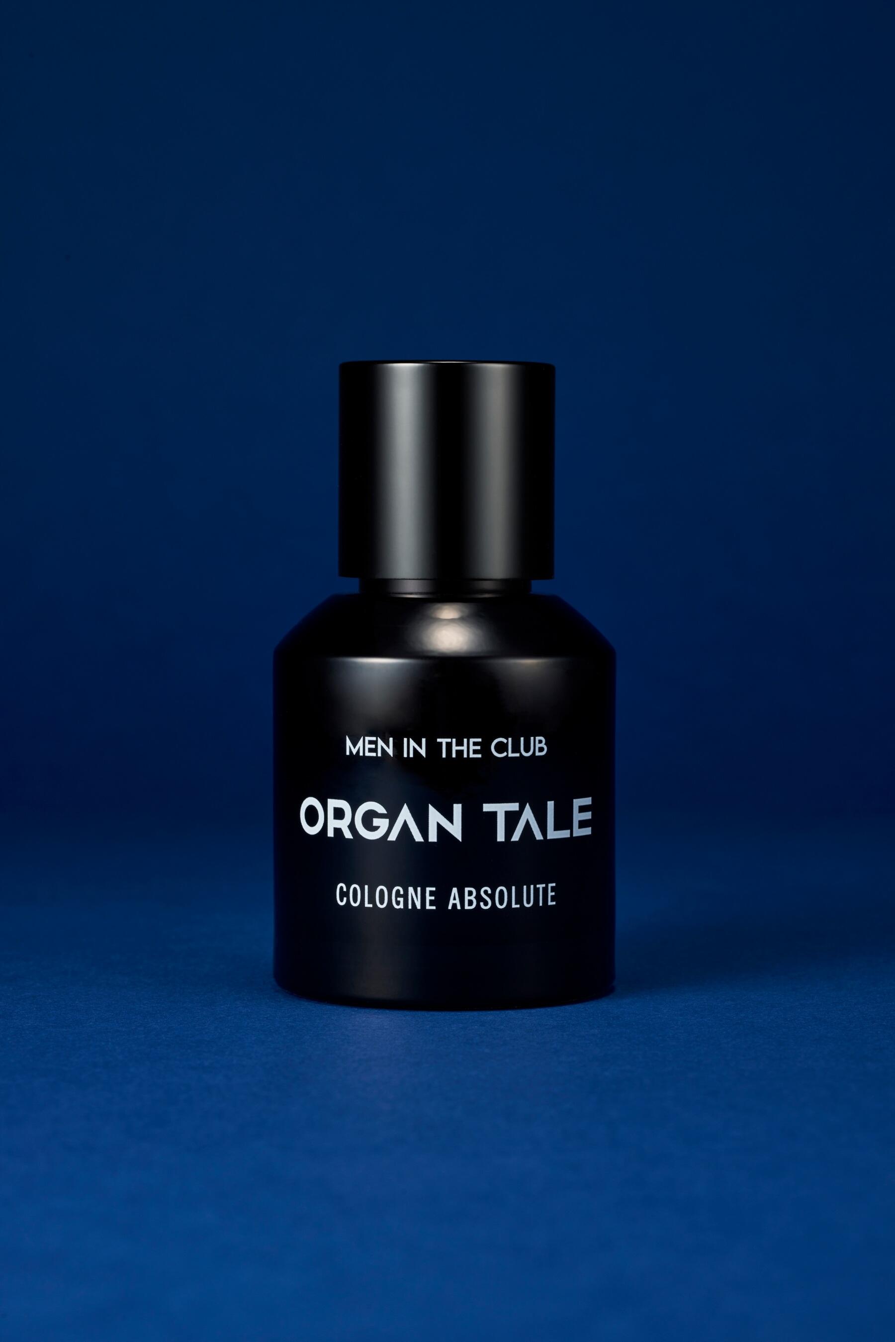 Men In The Club perfume against a blue backdrop