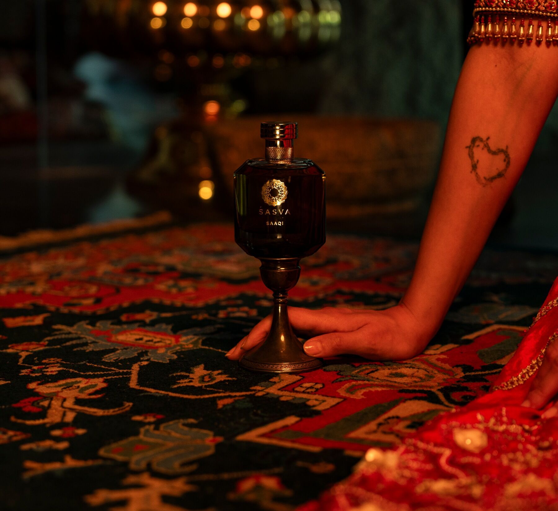 Saaqi next to an arm with a heart shaped tattoo on it