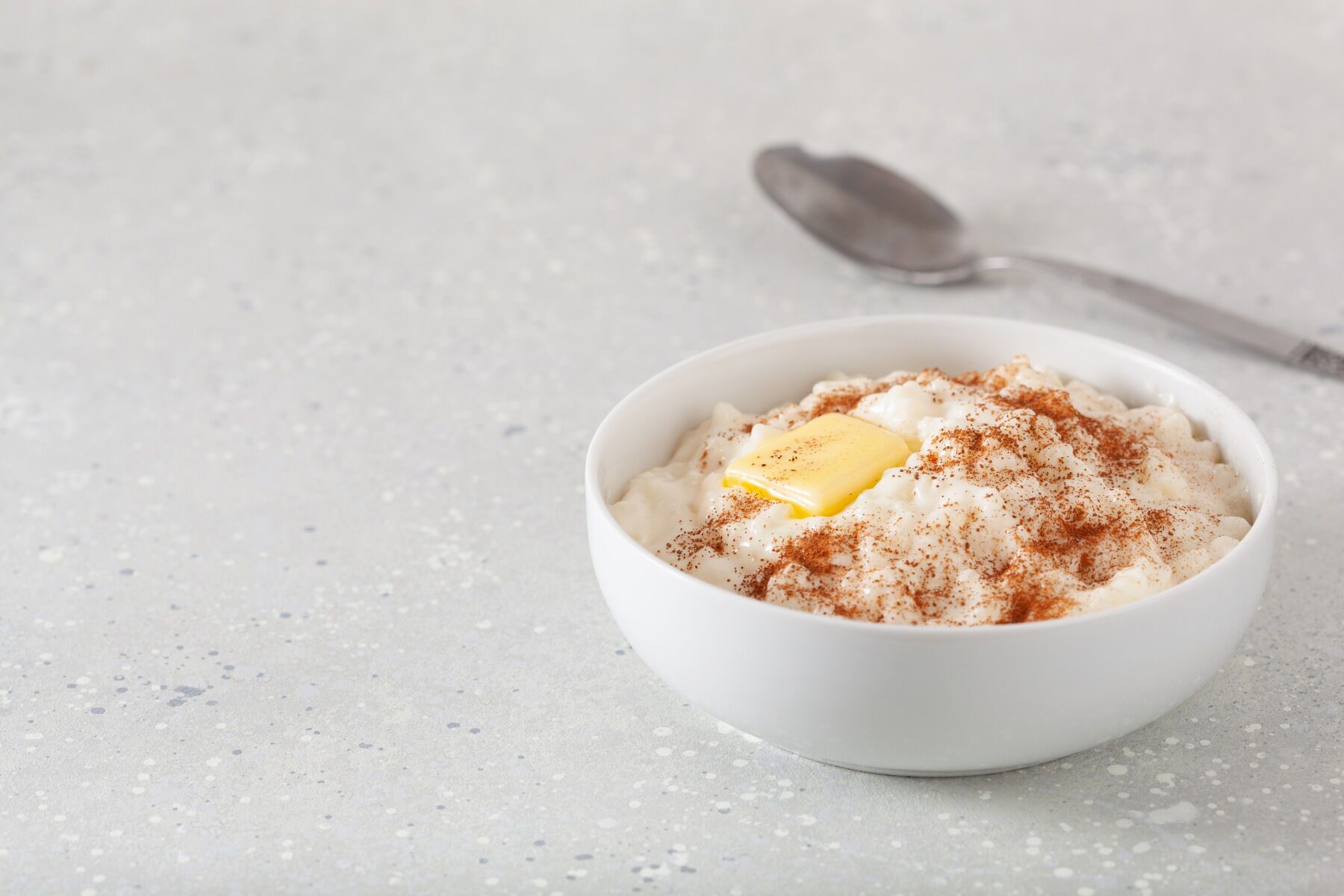 Norwegian rice pudding in a white bowl with butter and cinnamon on top