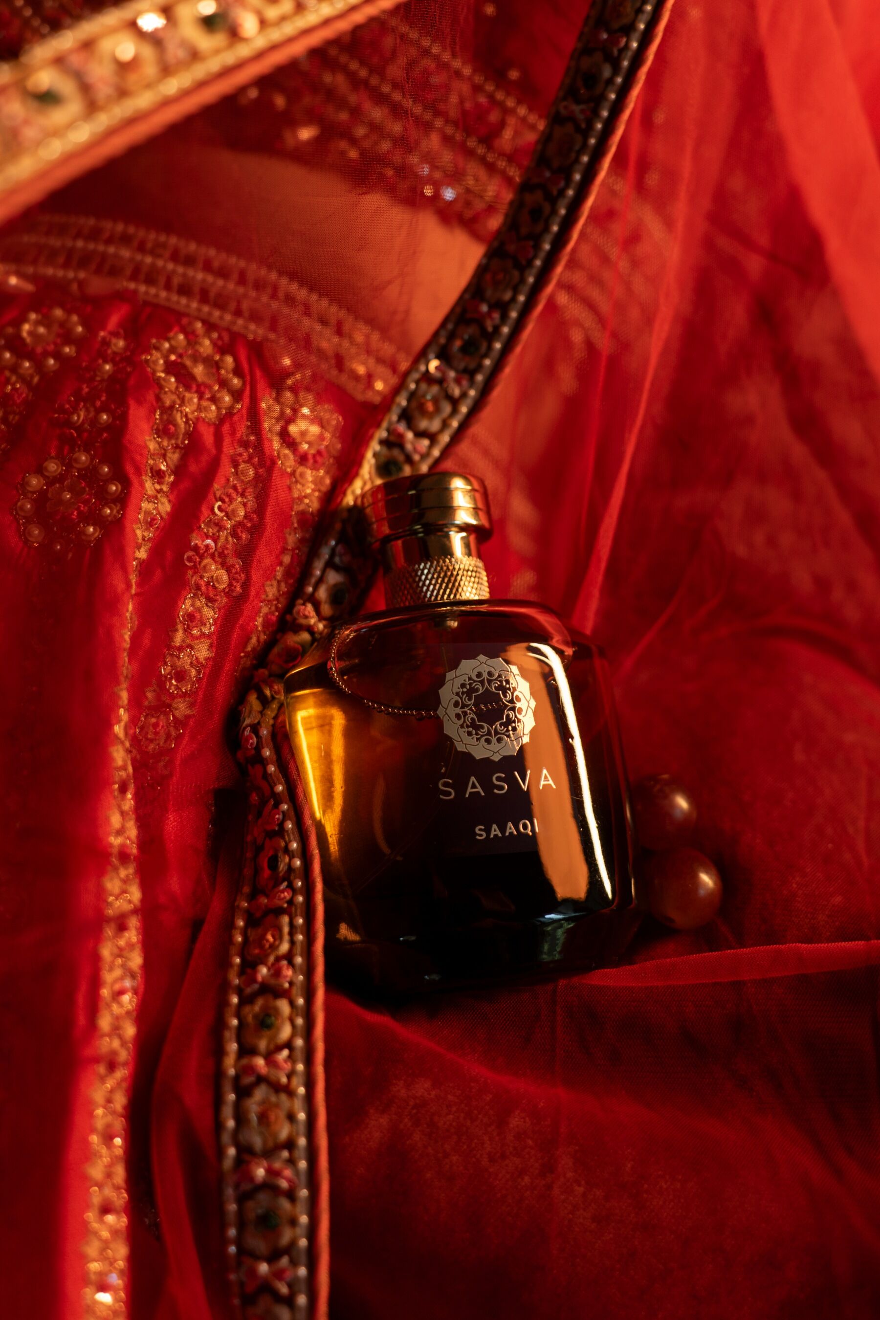 Saaqi on richly pattered red sari fabric