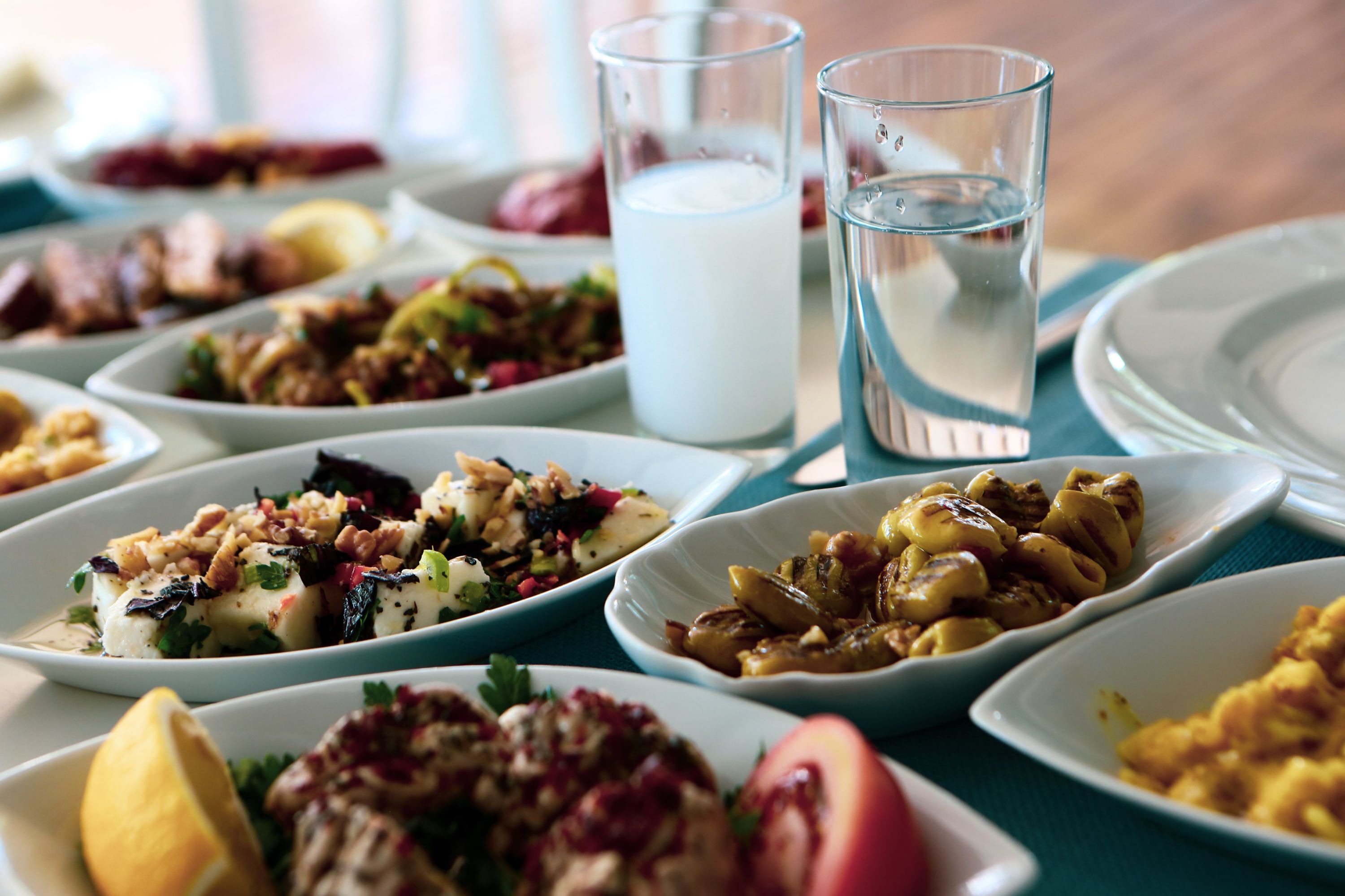 Greek dining table set with mezedes dishes, seafood and ouzo aperetif