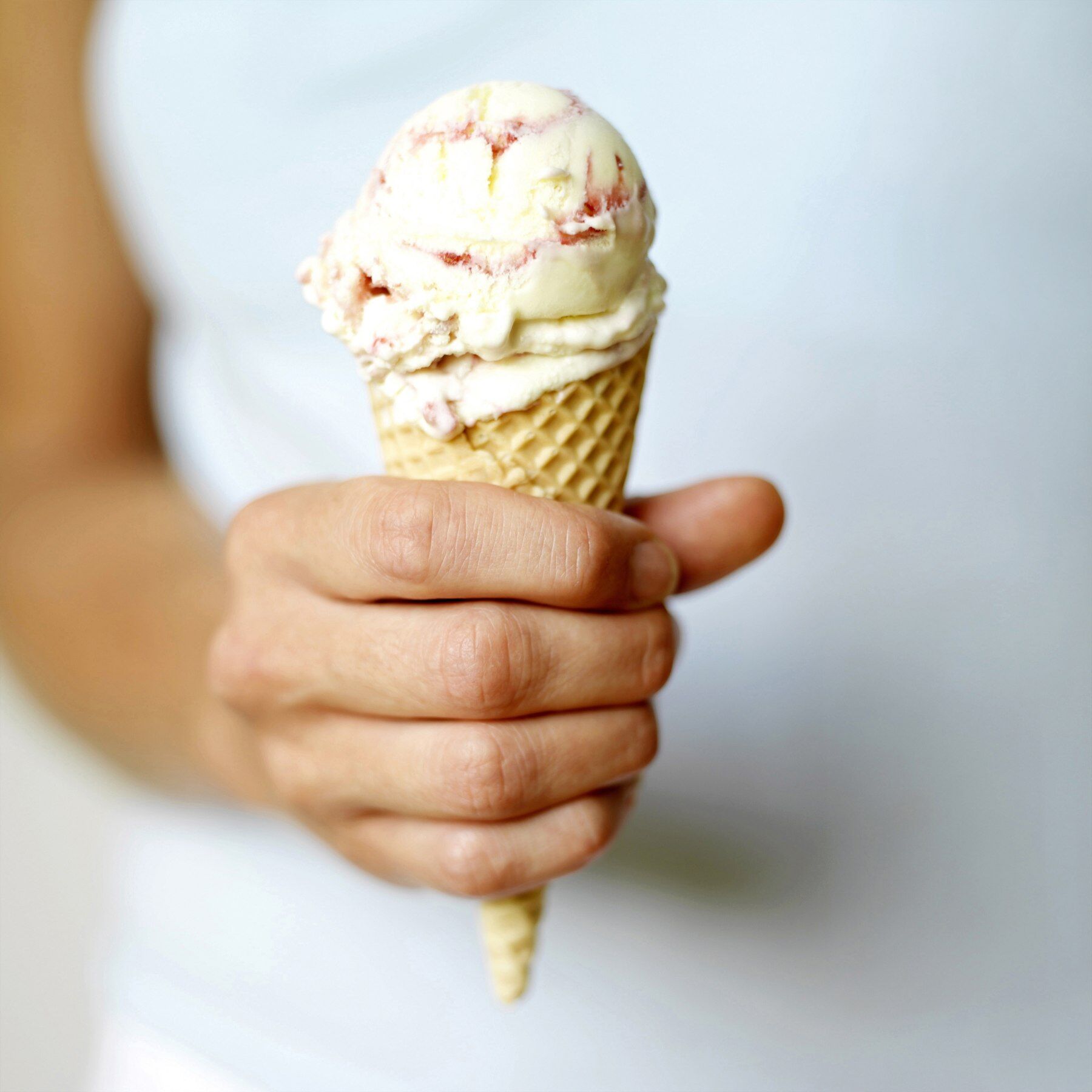 A girl holding a raspberry ripple ice cream cone