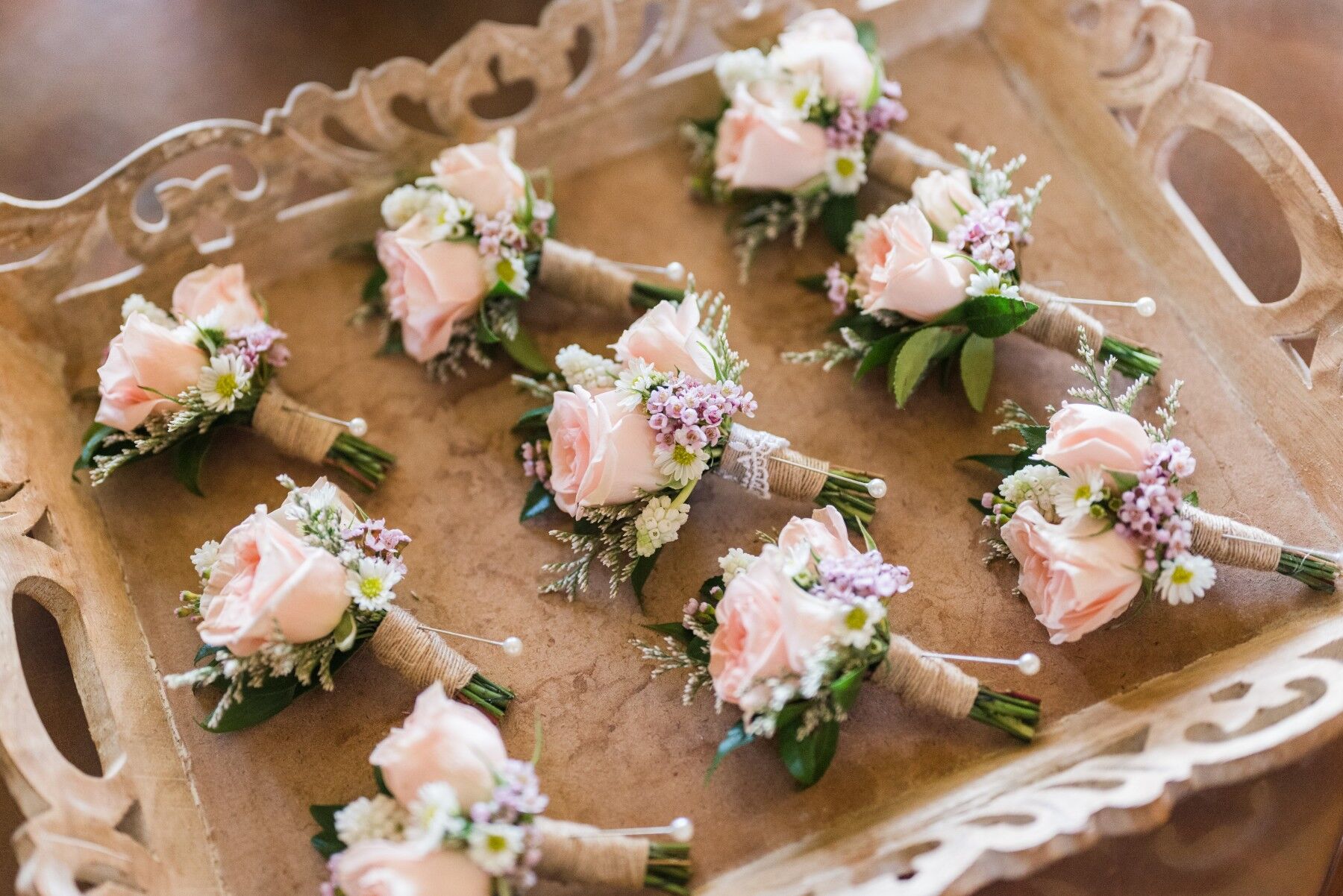 Small posy buttonholes ready to be worn, made of a variety of flowers