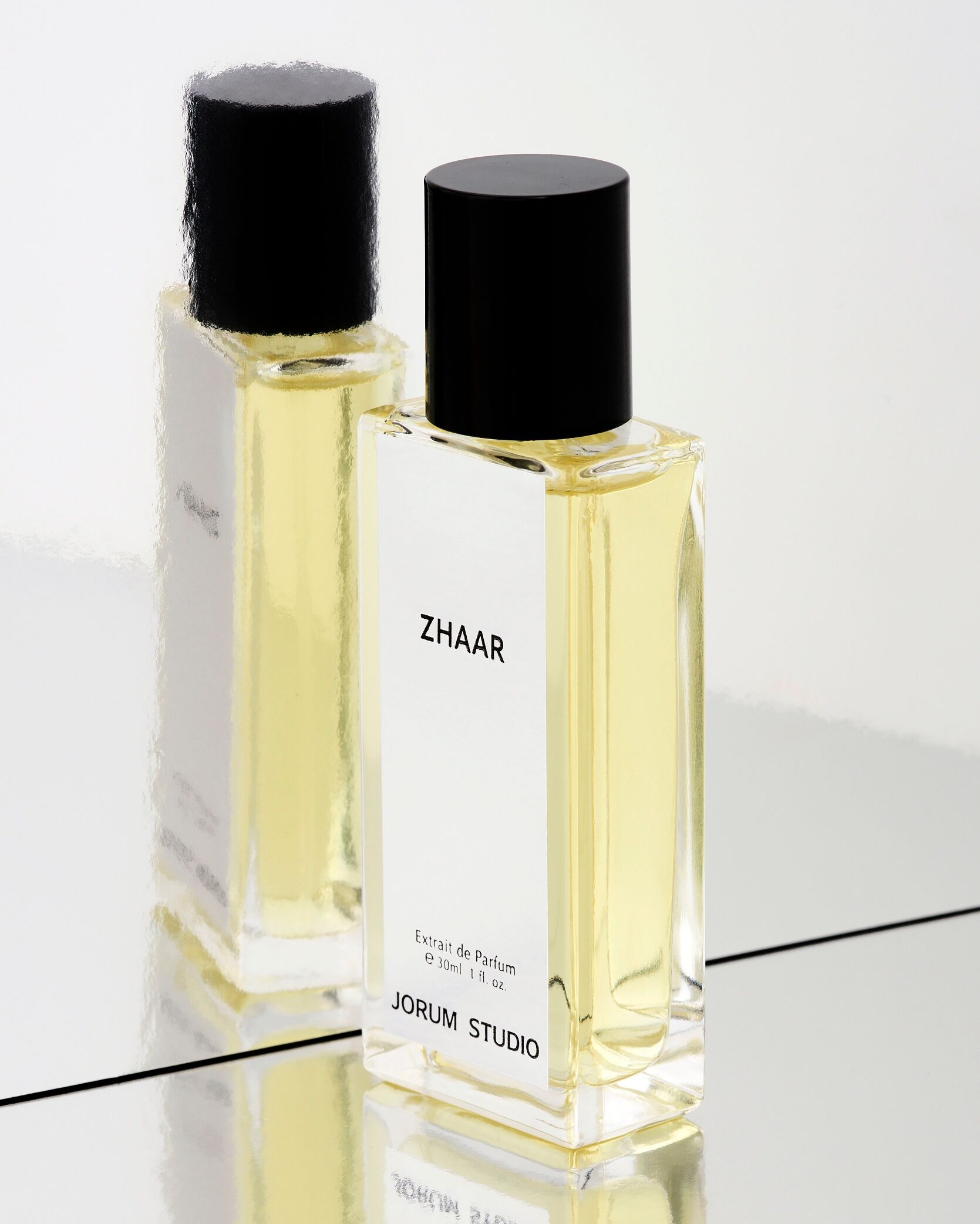 A bottle of Zhaar stood next to a wibbly mirror so the reflection is distorted