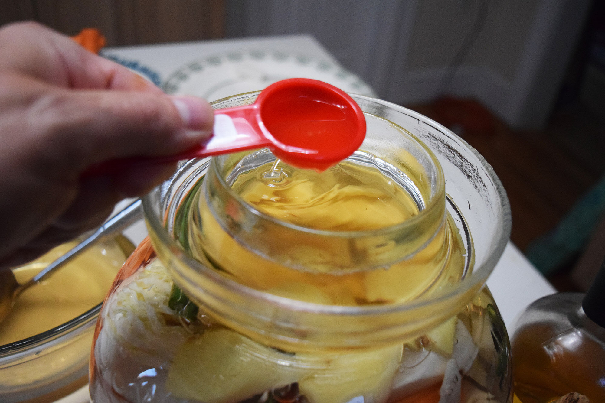 Filling alcohol at the top of the pickle jar.