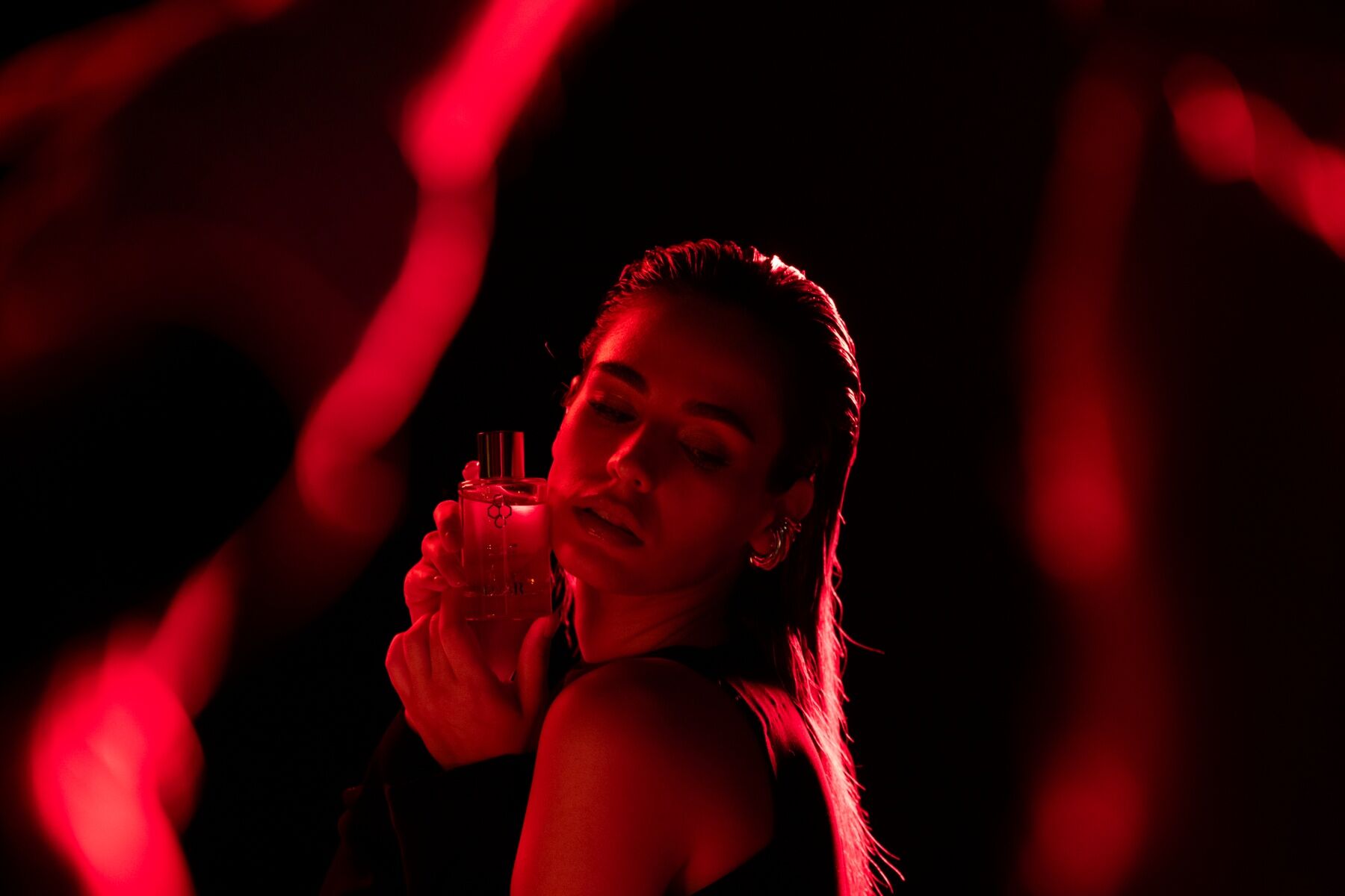 A woman bathed in red light, and red fabric, she appears to be dancing