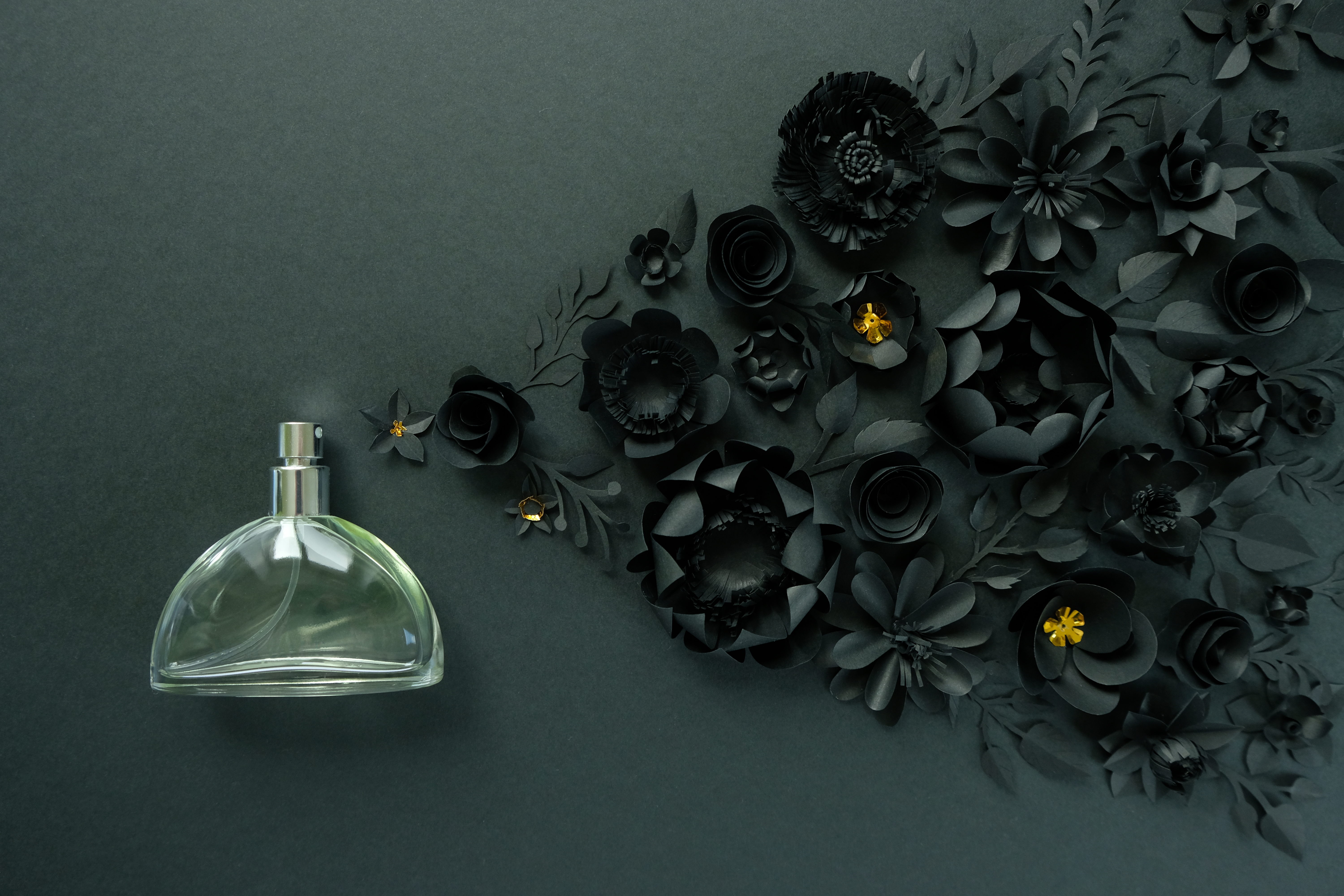 perfume bottle spraying figurative black roses