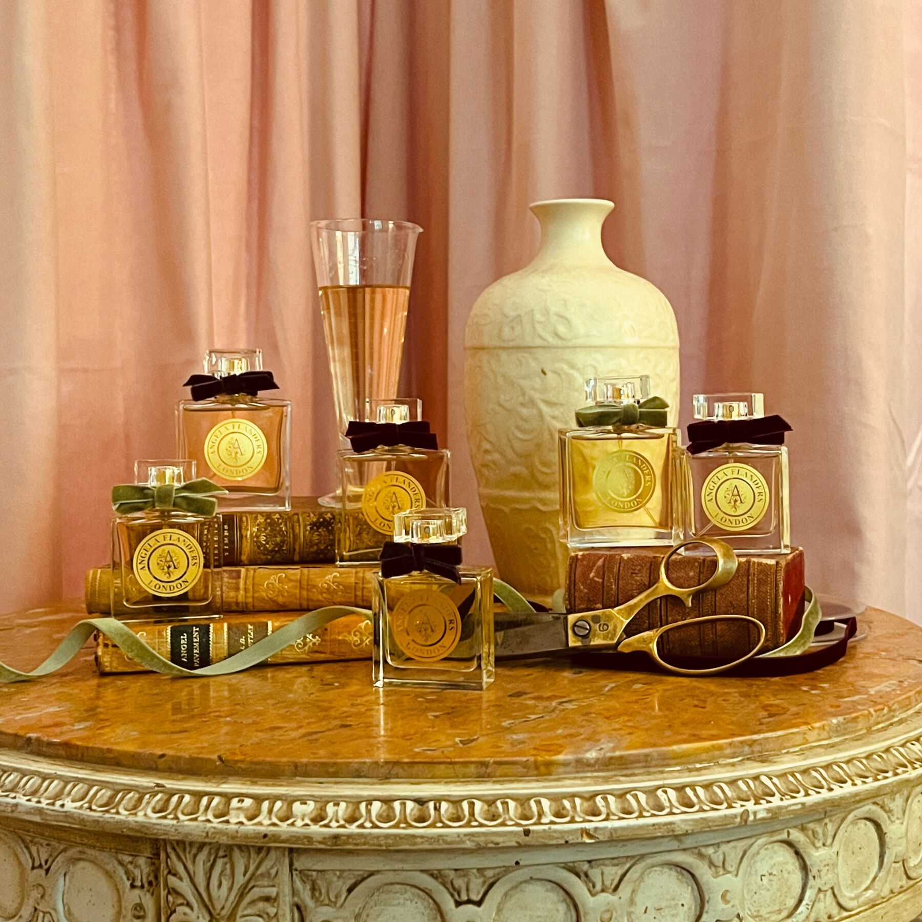 The Atelier Collection from Angela Flanders placed on a table against a pink backdrop