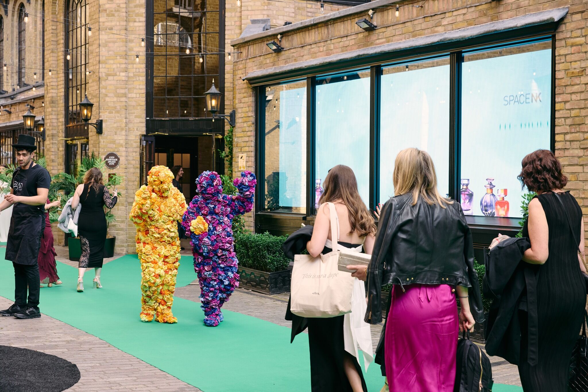 Two people dressed up in costumes that cover them with flowers