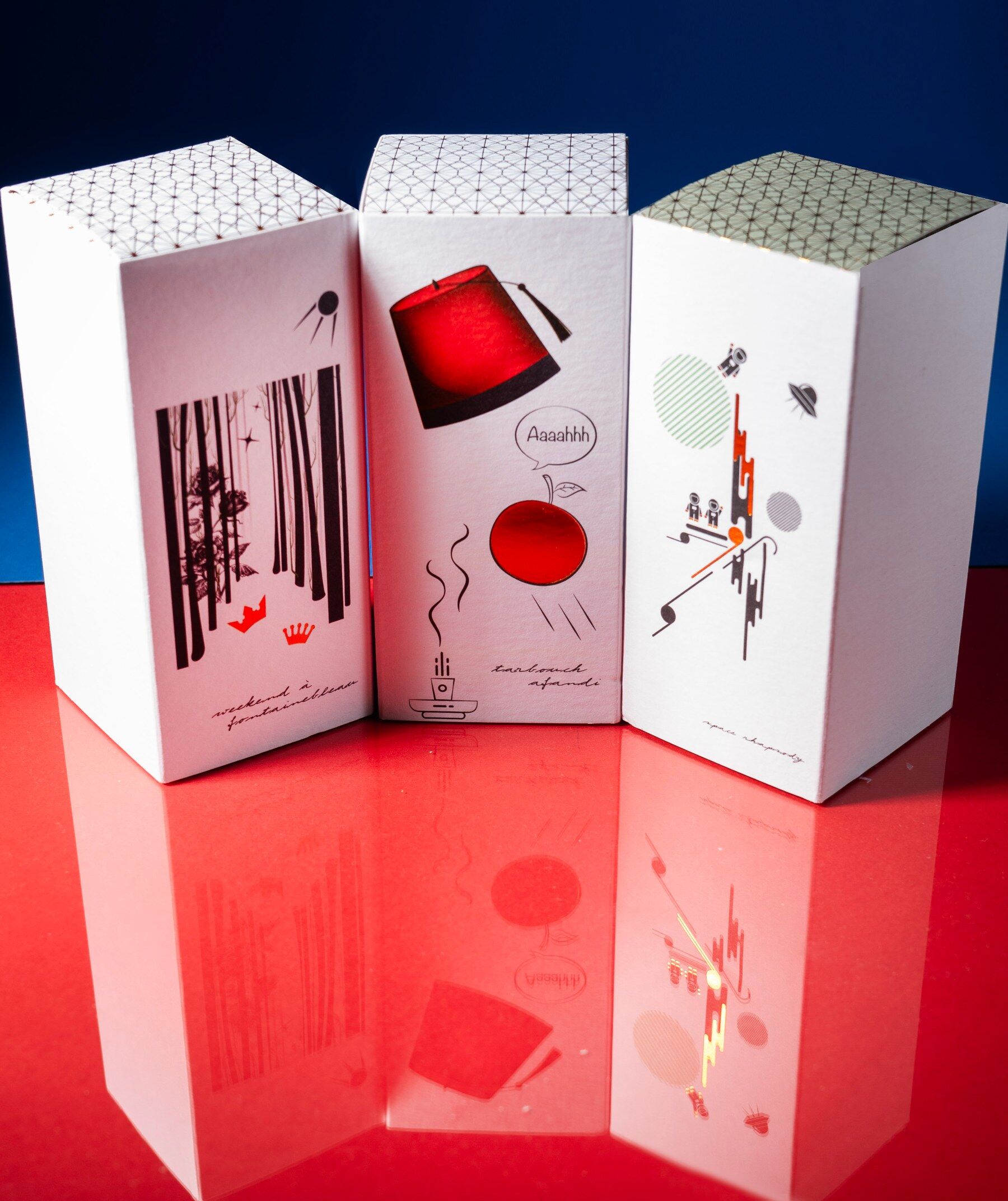 Ideo perfume boxes against a blue and red background