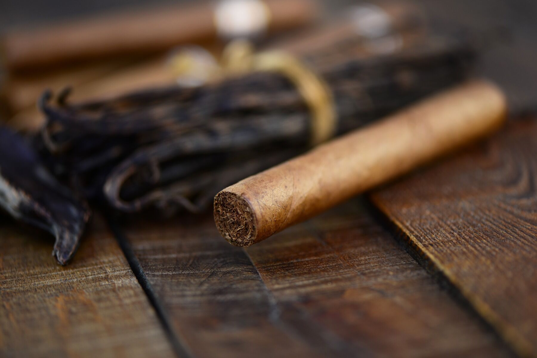 A cigar with vanilla fruits in the background