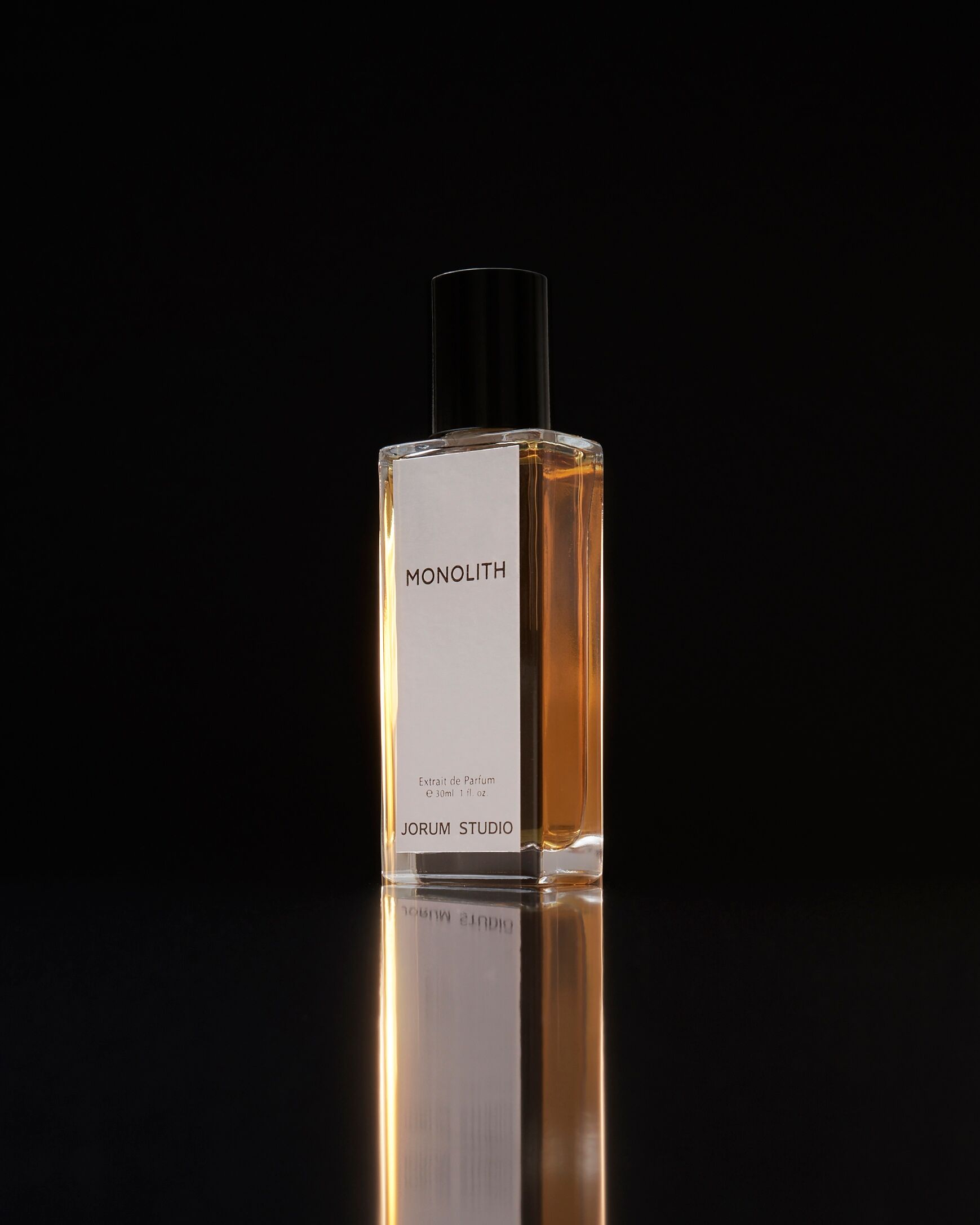 Monolith, a fragrance from Jorum Studio against a dark background and reflected at its base