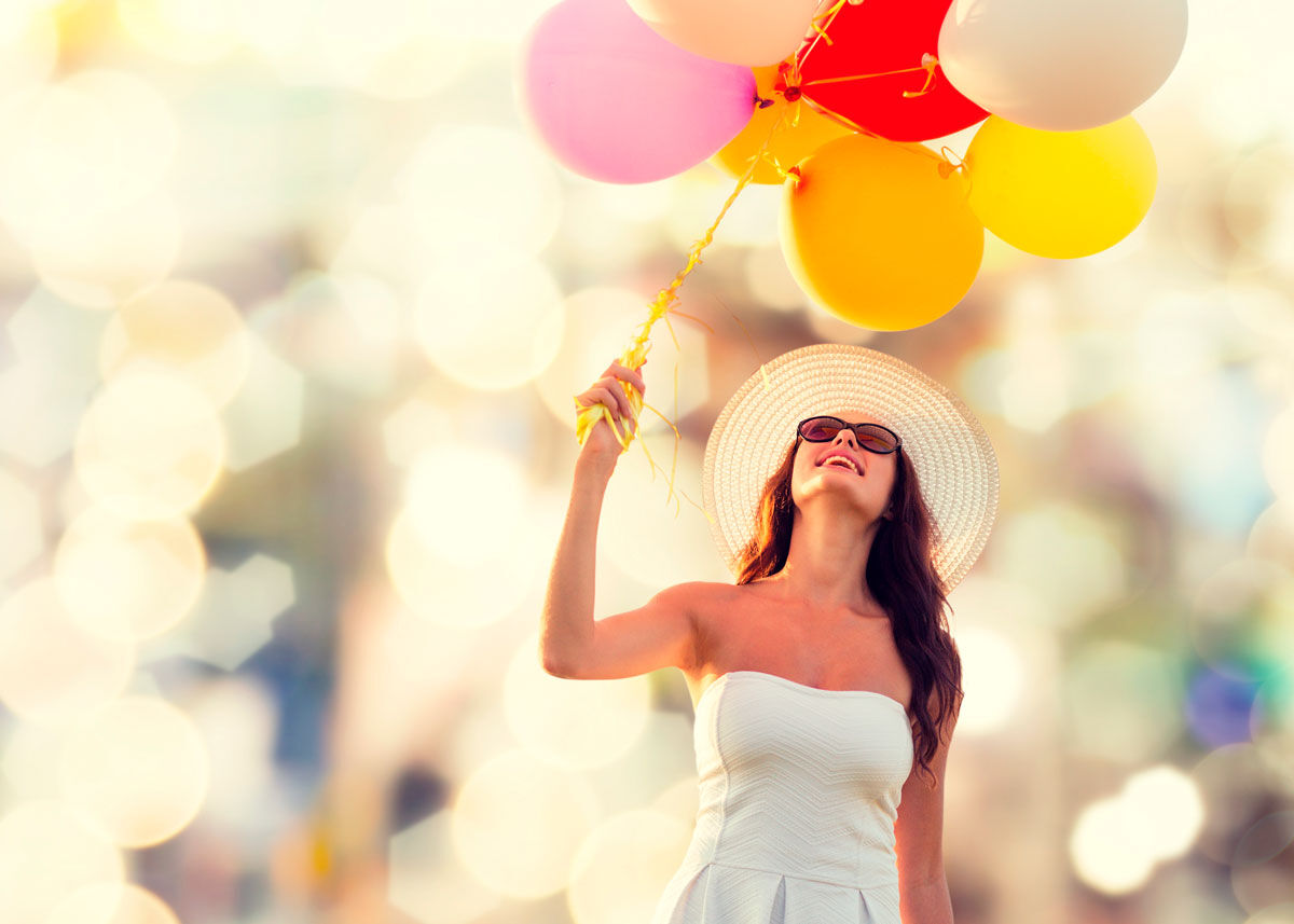 Young women in white dress holding baloons