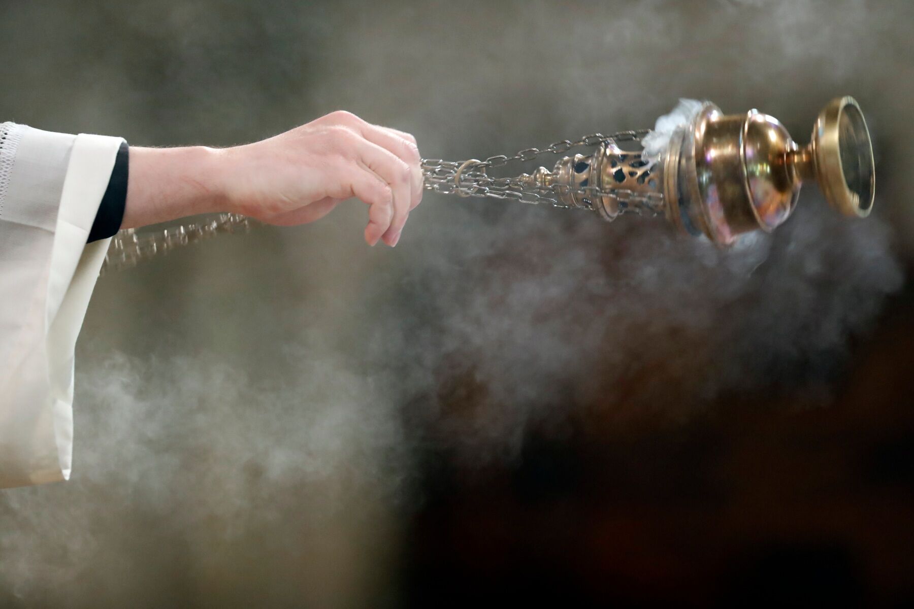 A smoking censer swinging from a hand