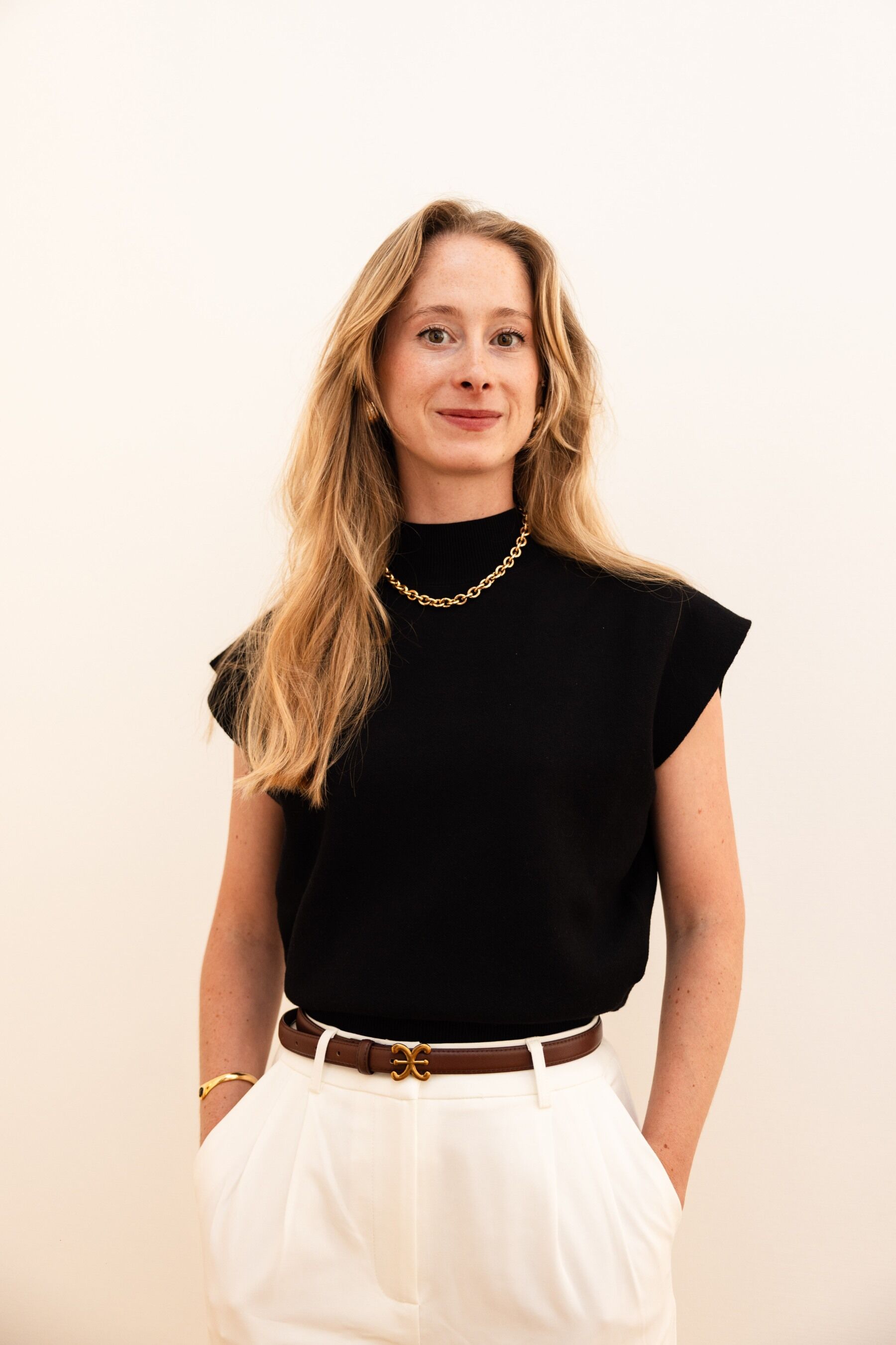 Margaux Le Paih Guerin in a black top and white trousers against a white background