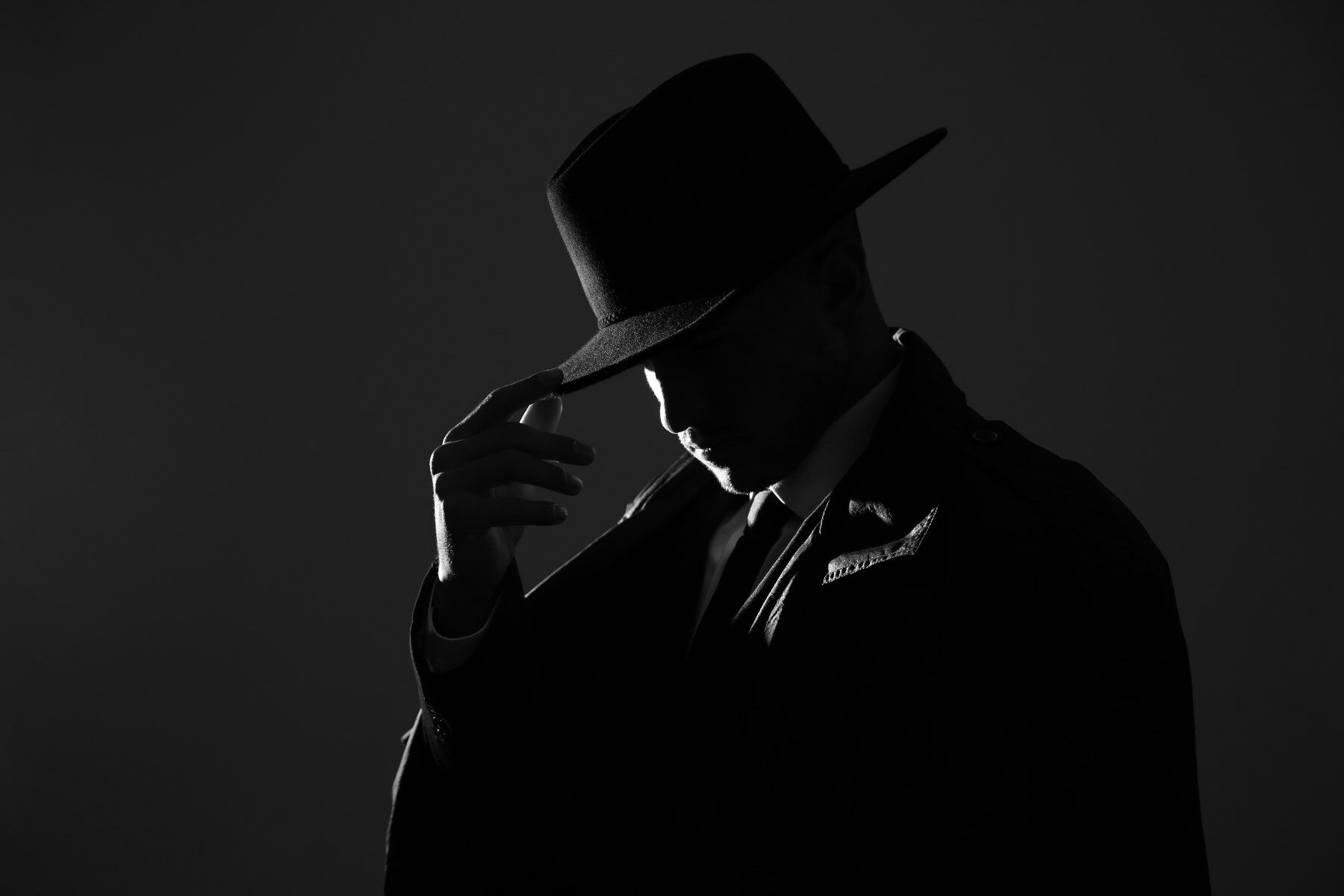 A man wearing a trilby in silhouette
