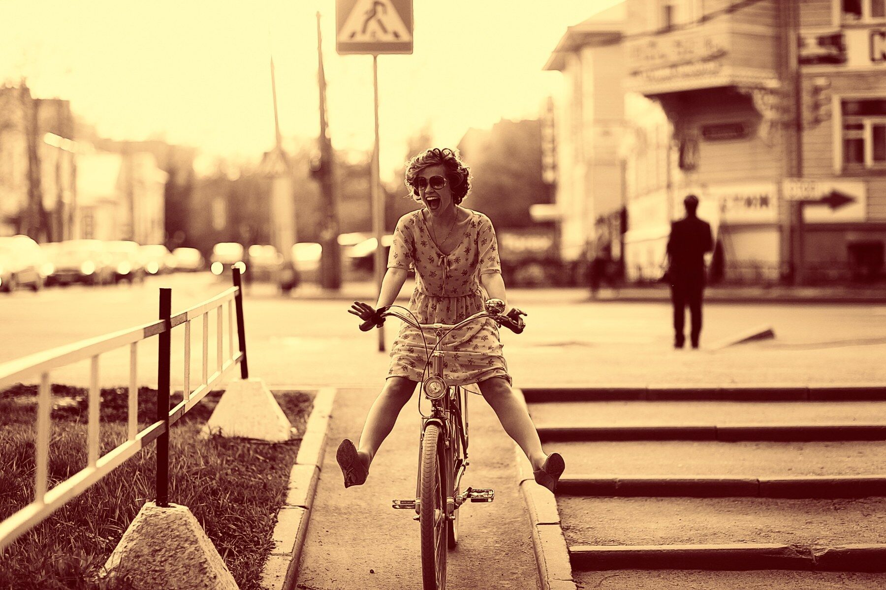 A lady in a day dress riding a bike