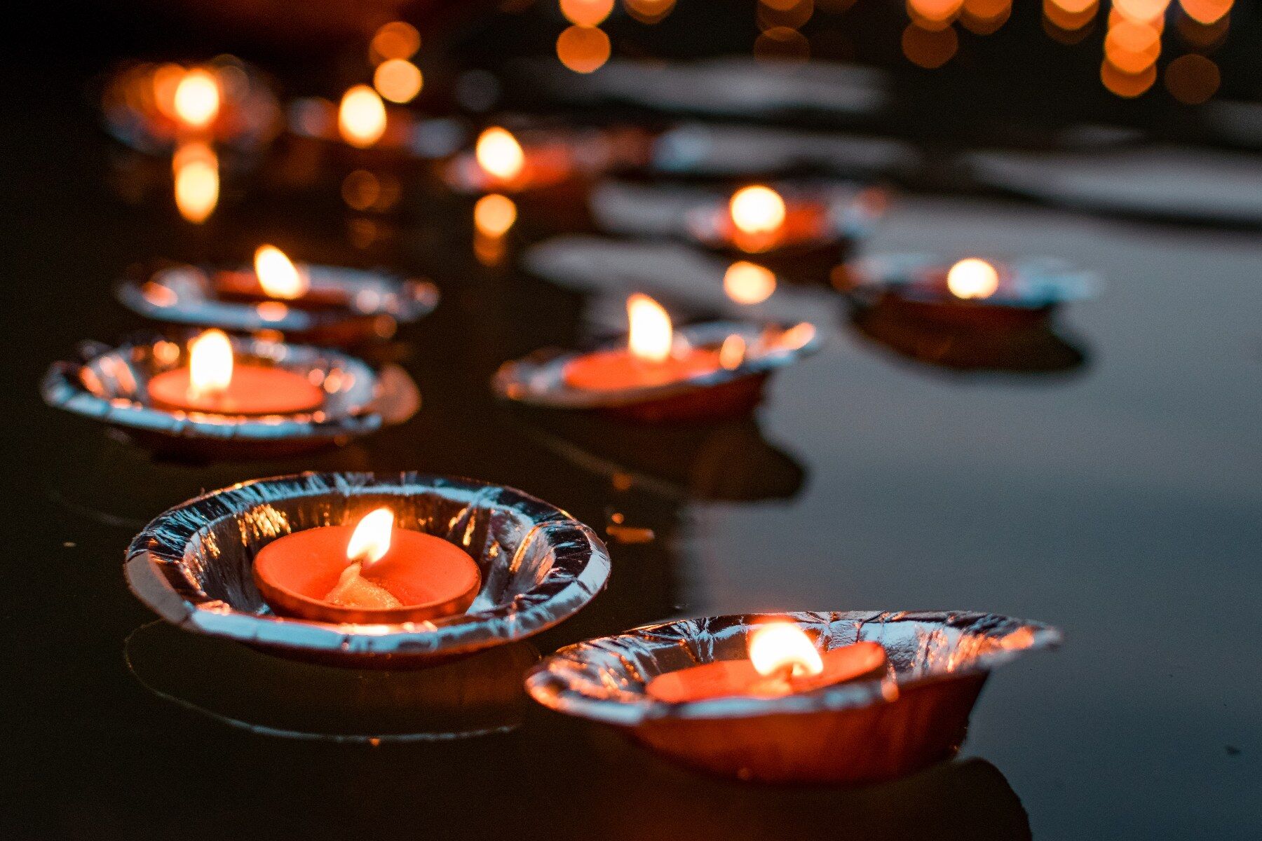 Candles held in little holders floating on water