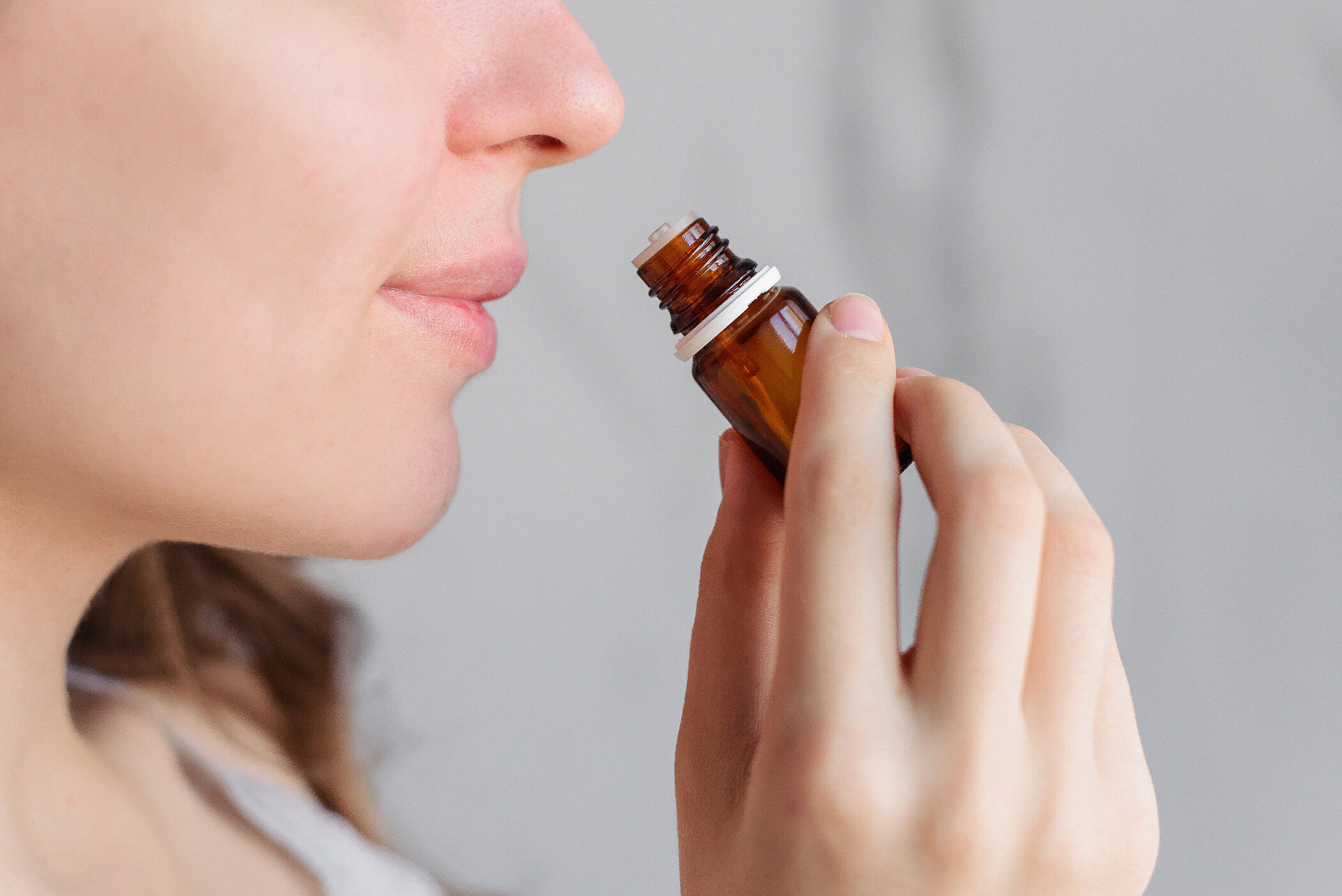 woman smelling a small bottle