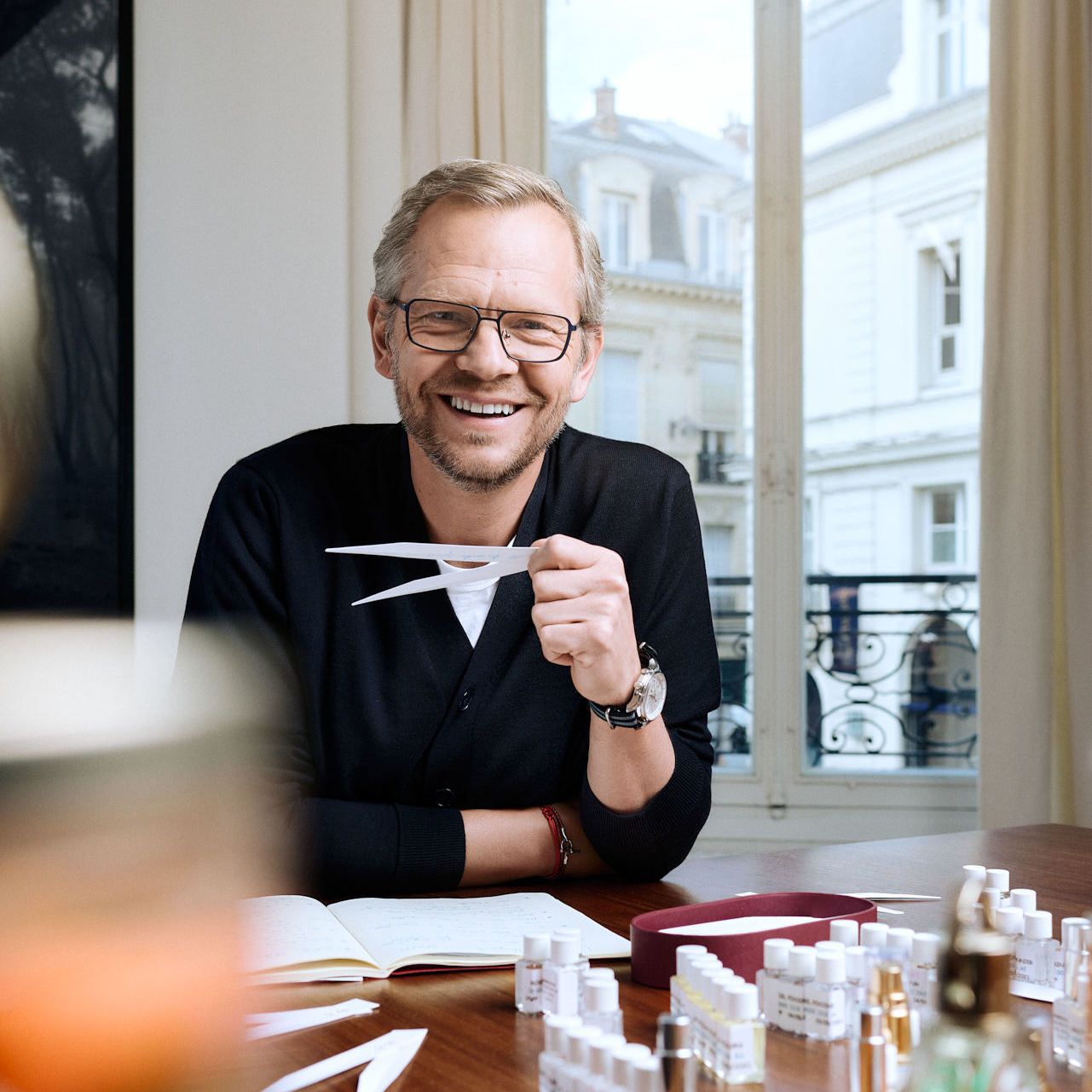 Jean Jacques perfumer holding mouillettes at his desk