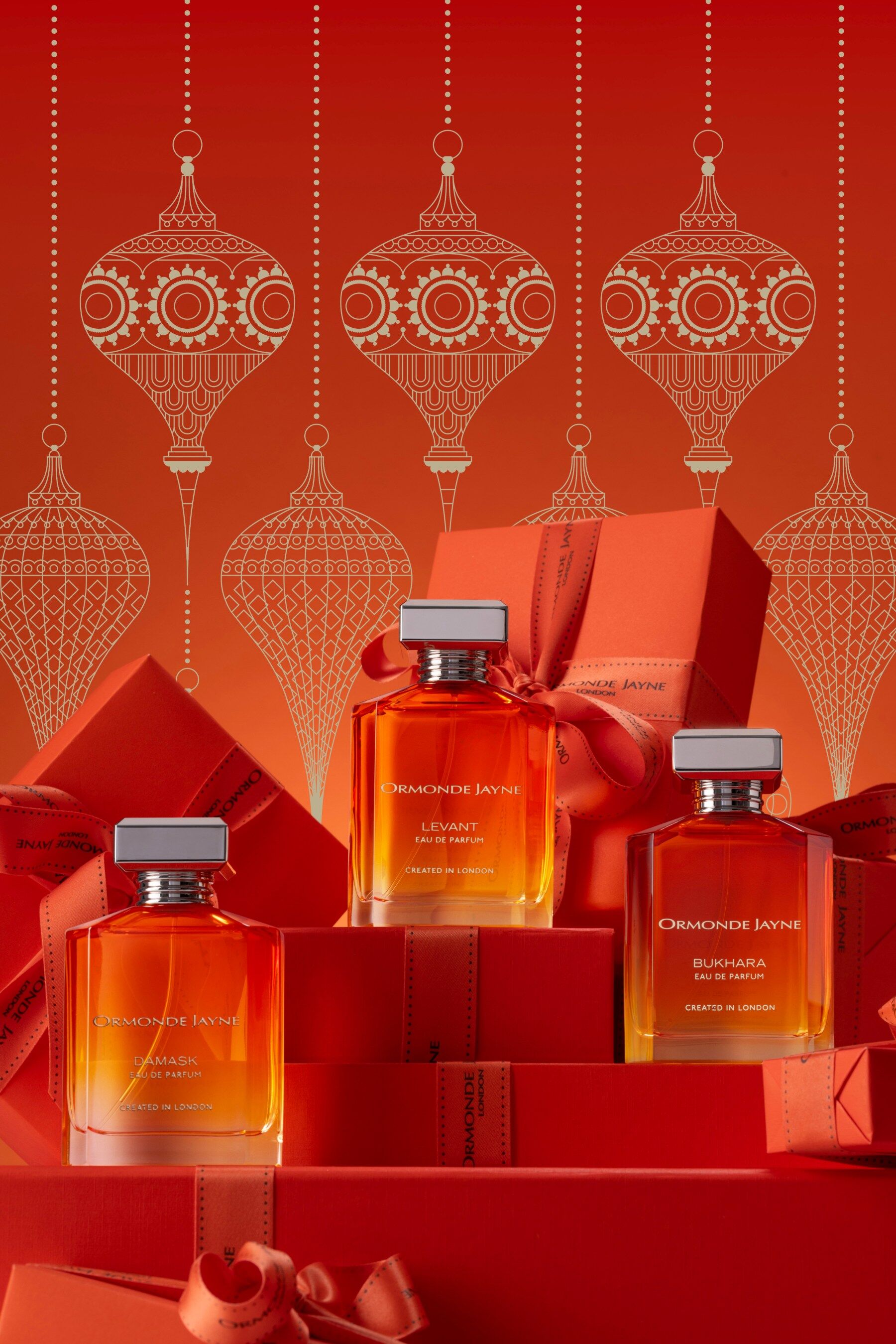Three perfumes on a red festive backdrop