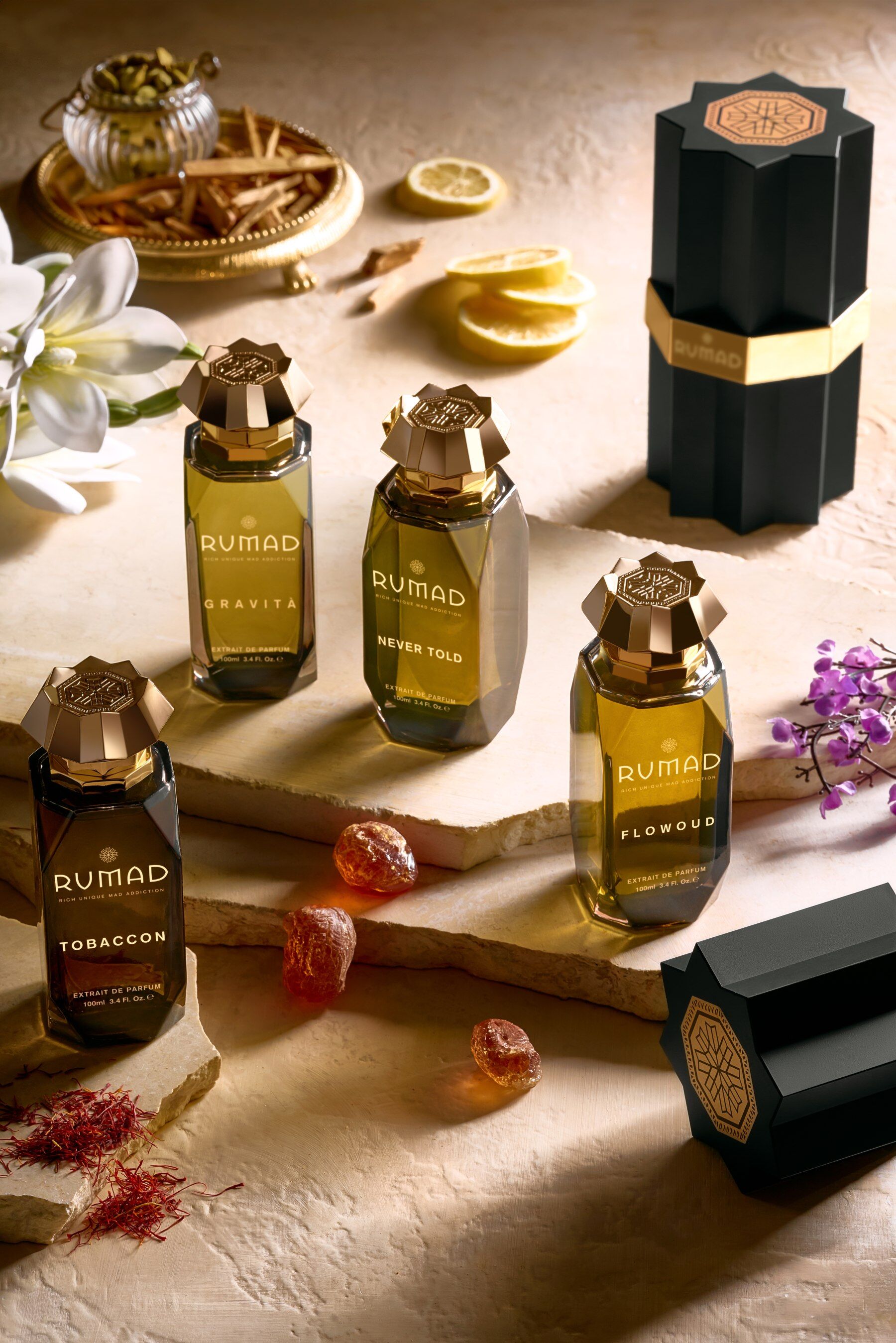Rumad fragrances stood on a pale stone surrounding with ingredients dotted about