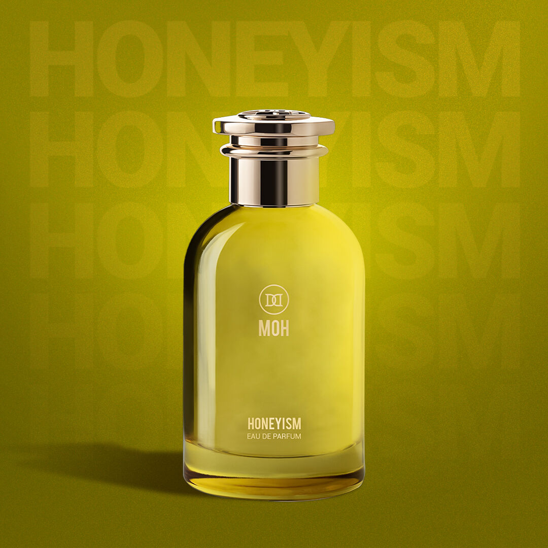 A bottle of honeyism on a greeny yellow backdrop with the name faintly showing