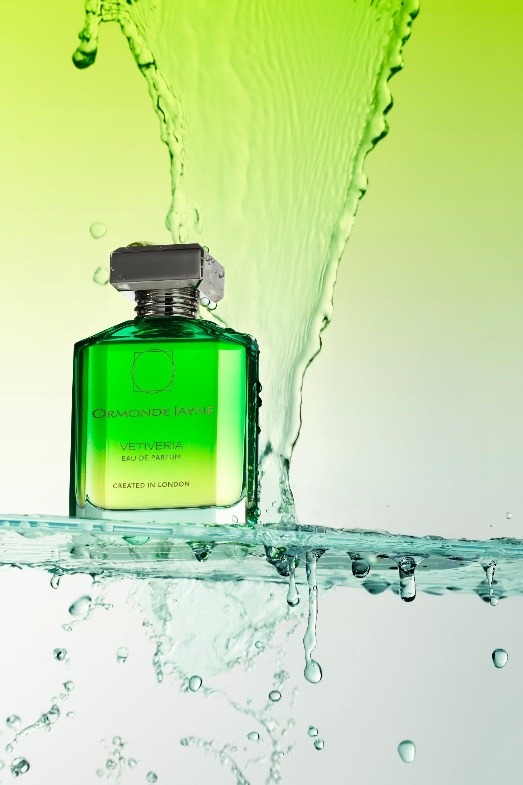 A bottle of Vetiveria with a splash of water and a green backdrop