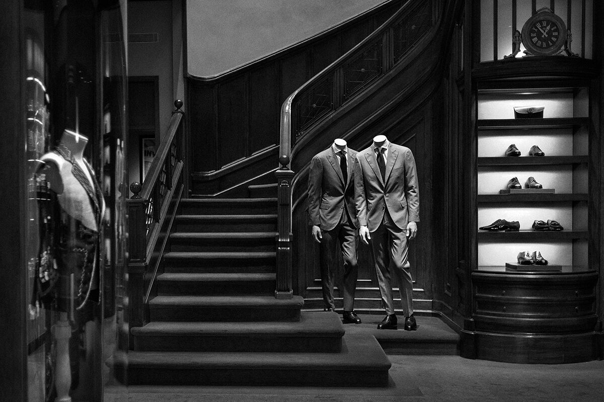 A black and white image of the staircase of the Santa Eulalia store with manequins
