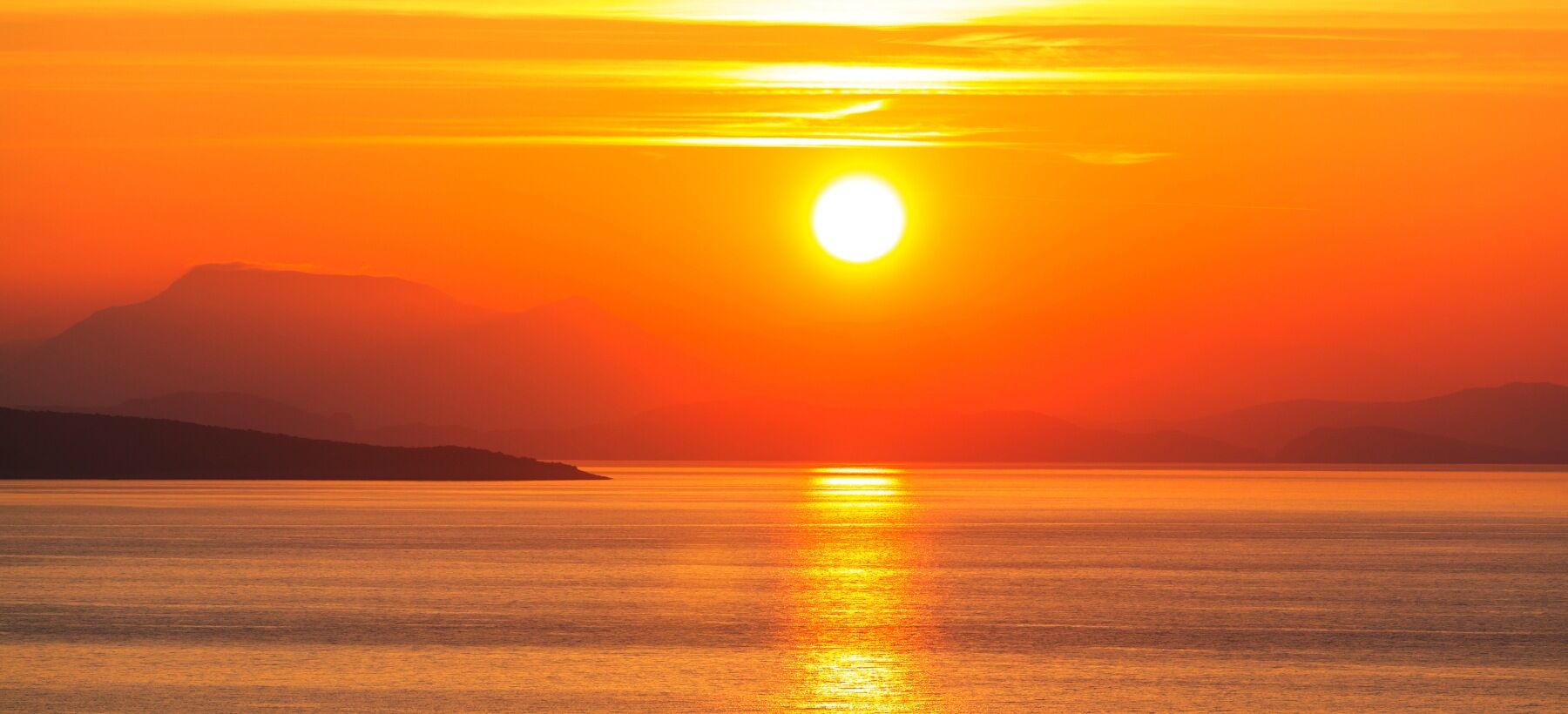 A sunset over the sea in Greece showing beautiful orange and red colours