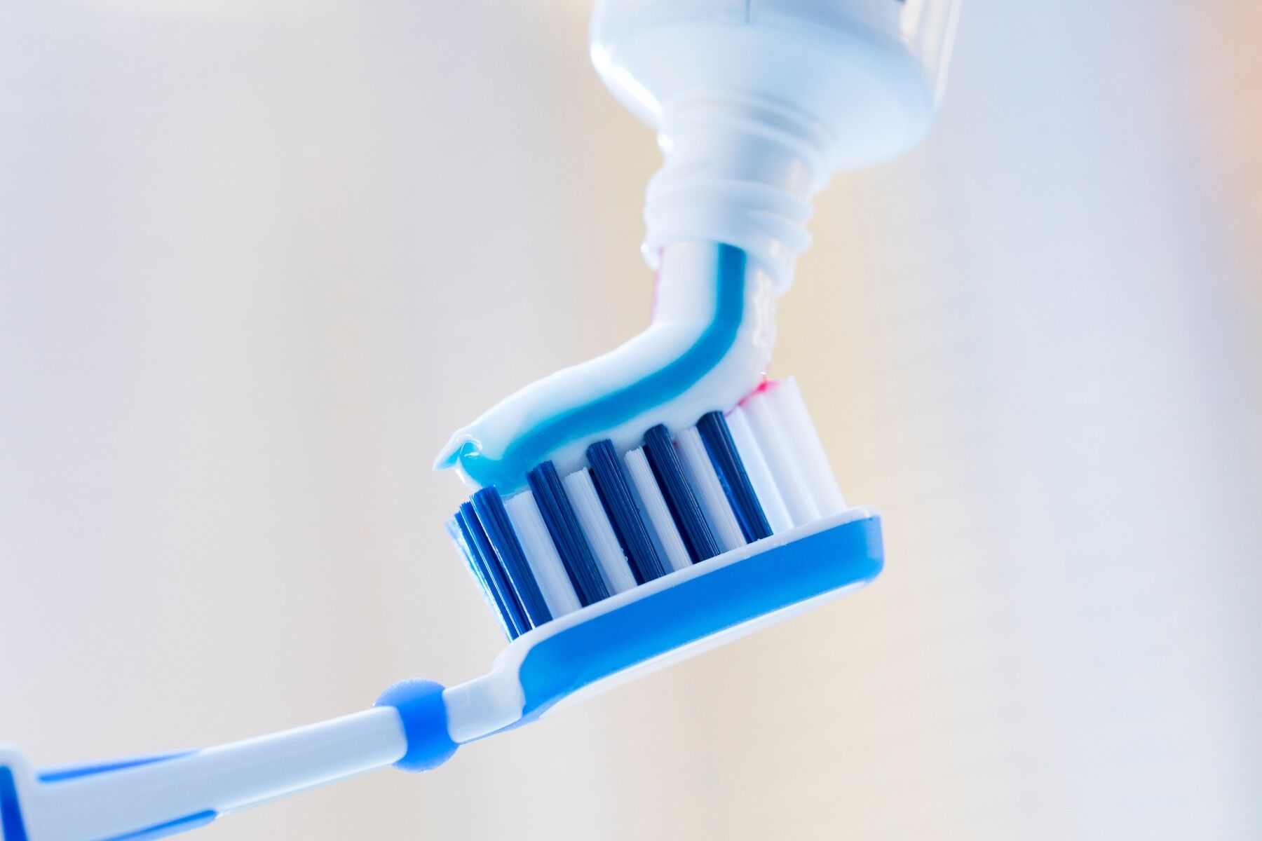 Toothpaste being squeezed onto a toothbrush