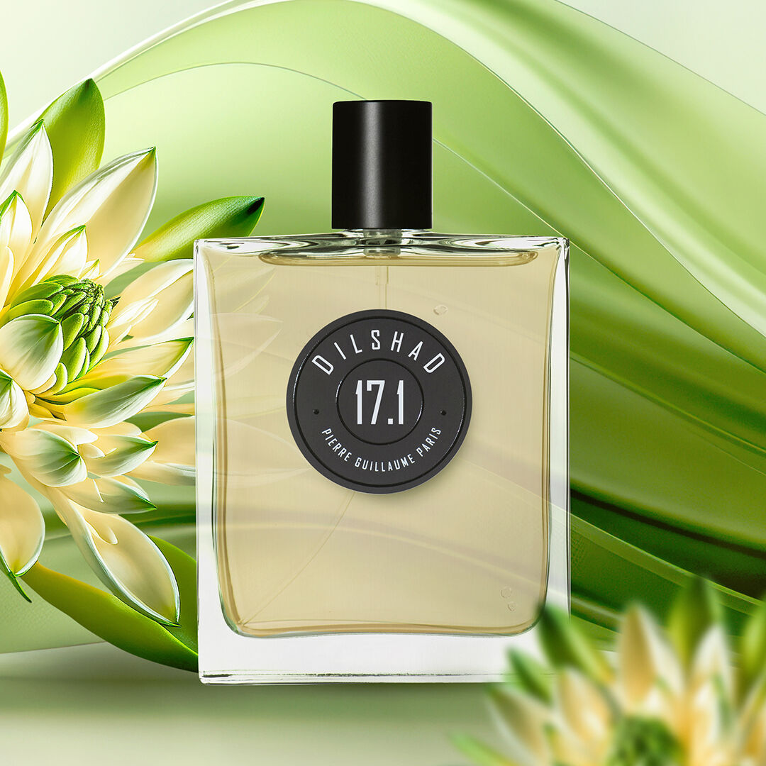 A bottle of Dilshad set against a swirling green backdrop with tuberose flowers