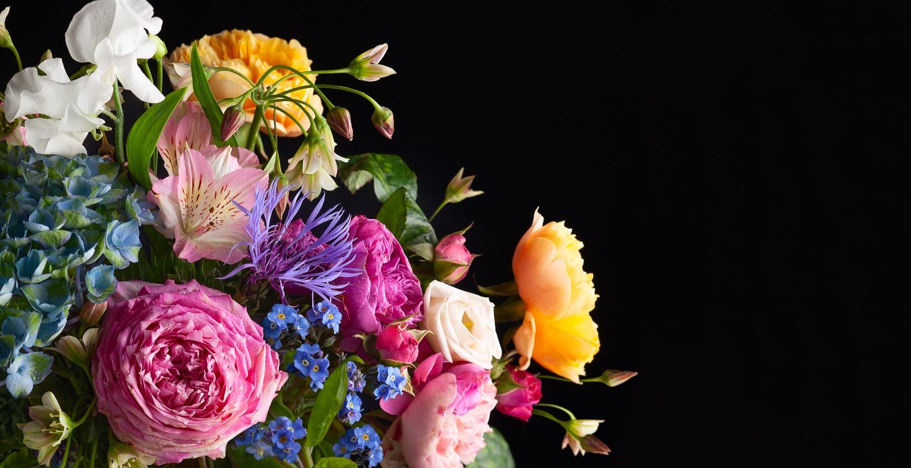 A bright bouquet of flowers on a black background