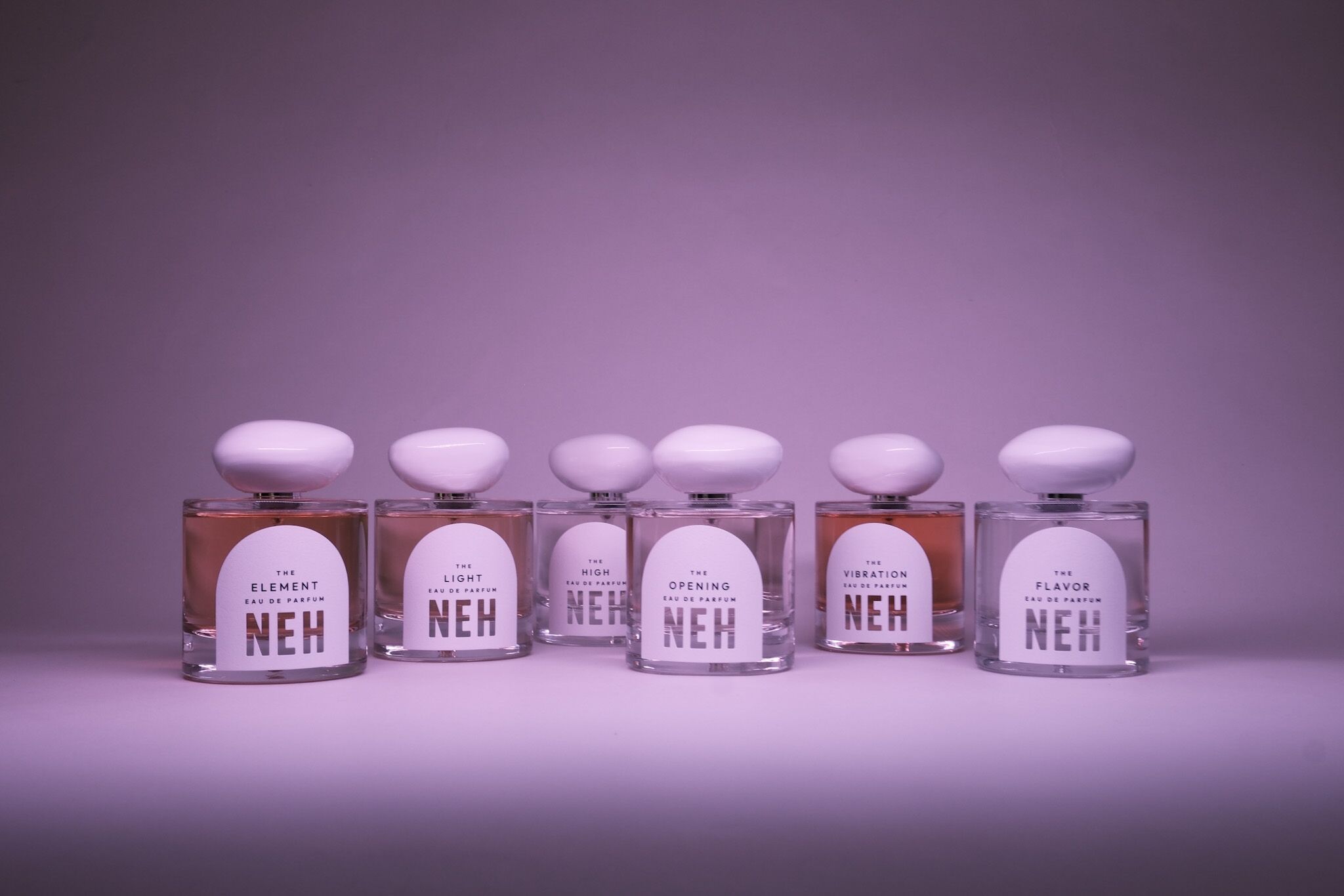 A group of Neh perfumes on a purple backdrop